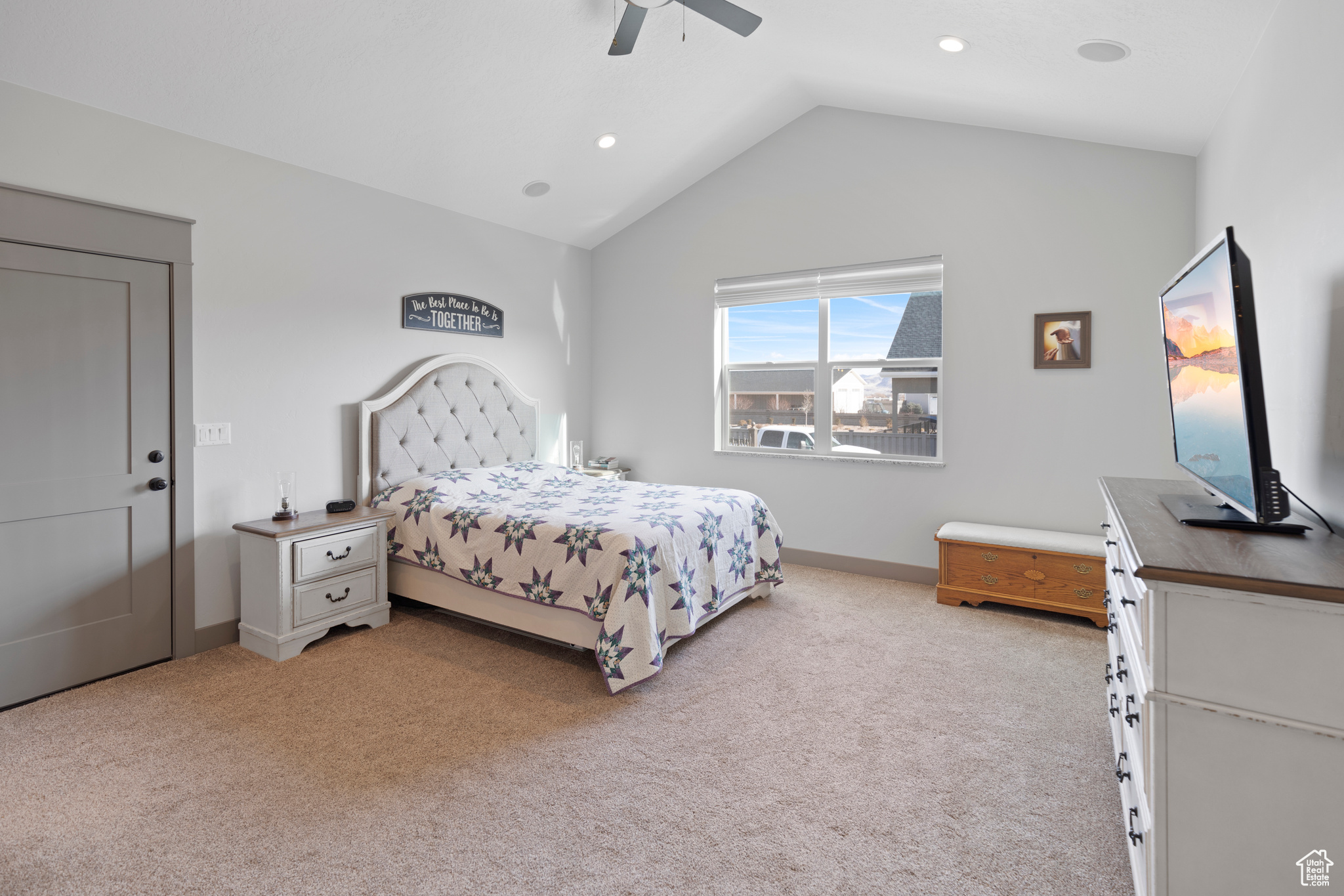 Master bedroom with lofted ceiling, light colored carpet, and ceiling fan