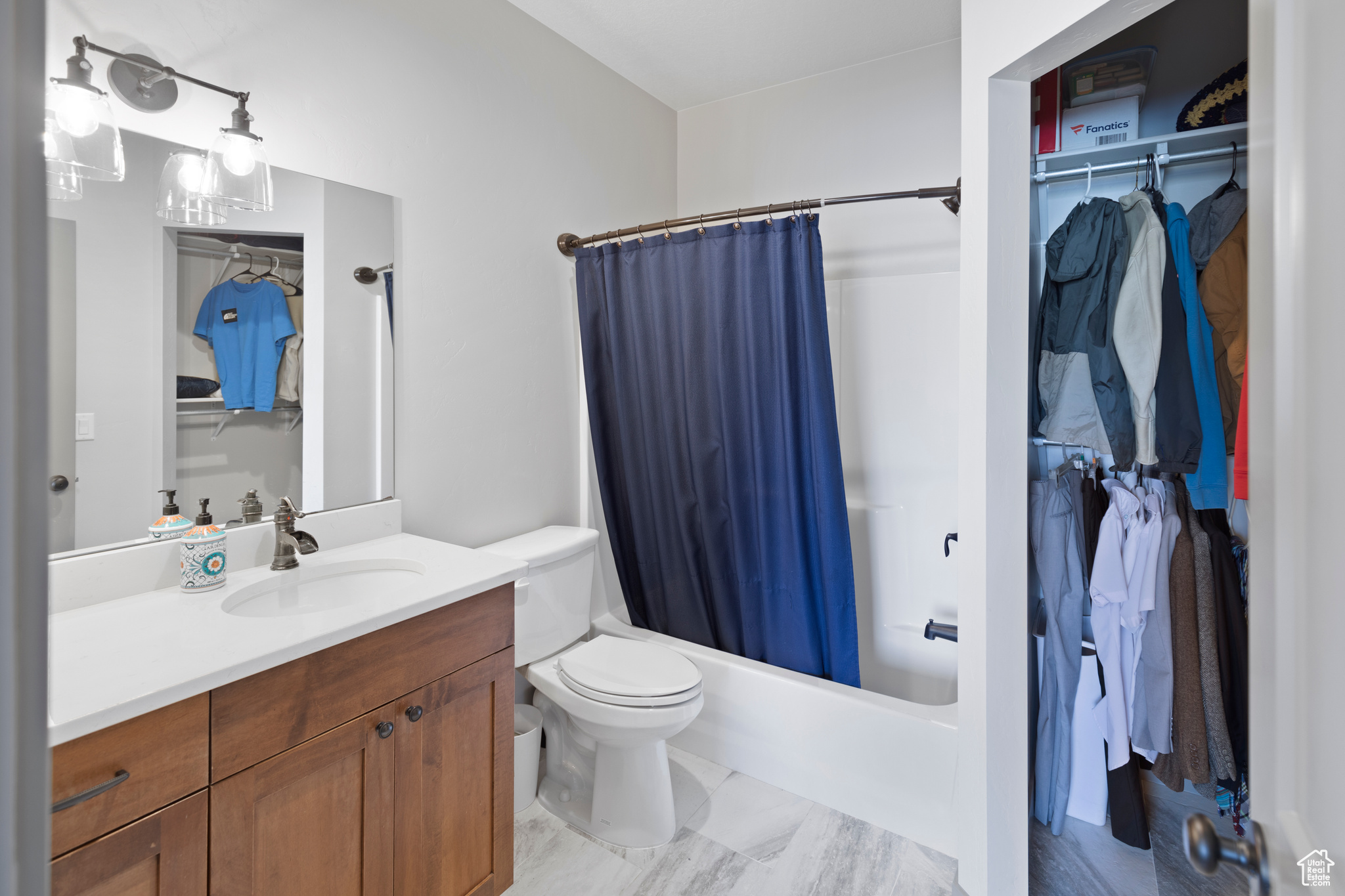 Full bathroom with toilet, vanity, and shower / bath combo with shower curtain