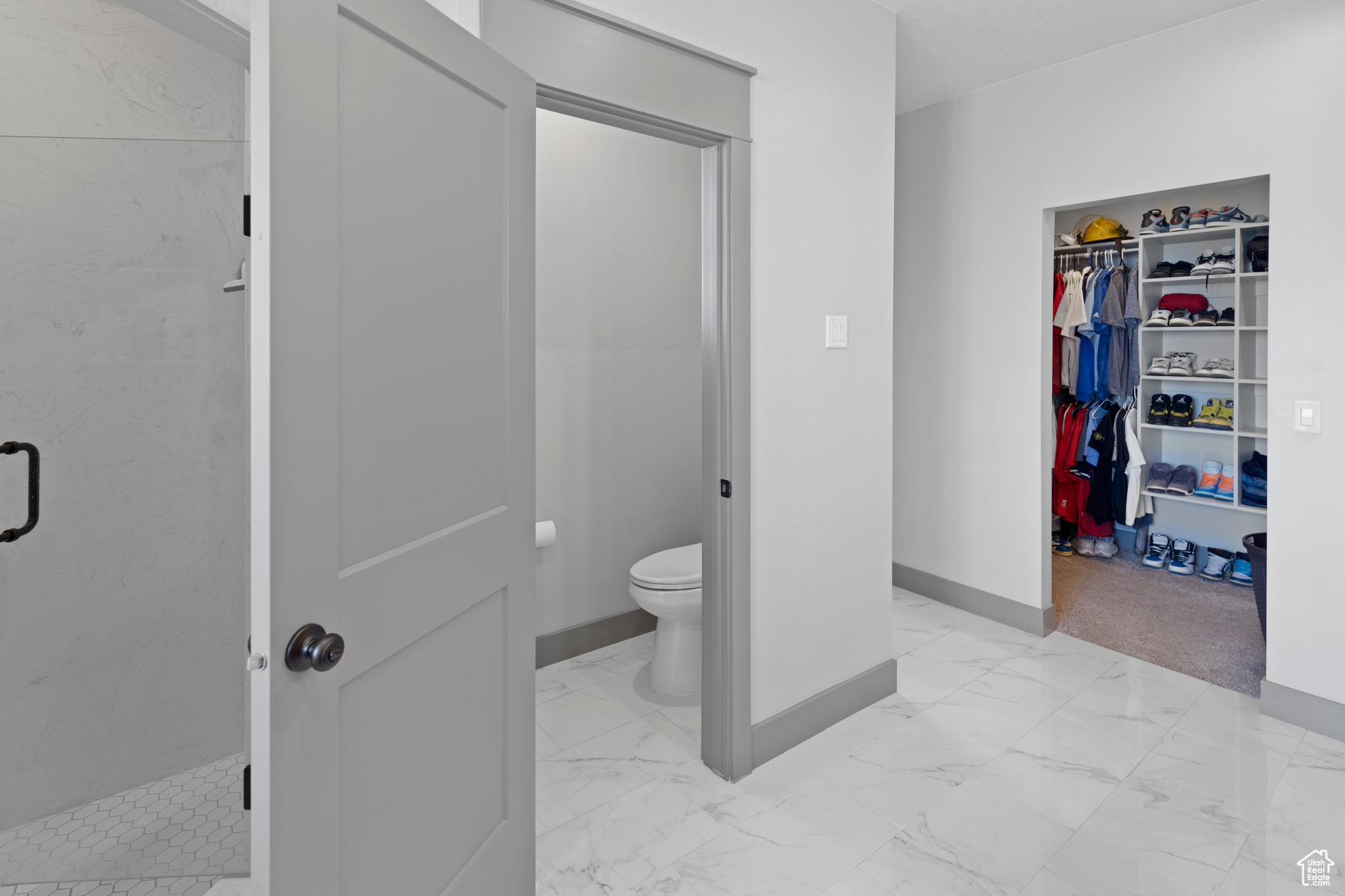 Bathroom featuring toilet, tile flooring, and tiled shower