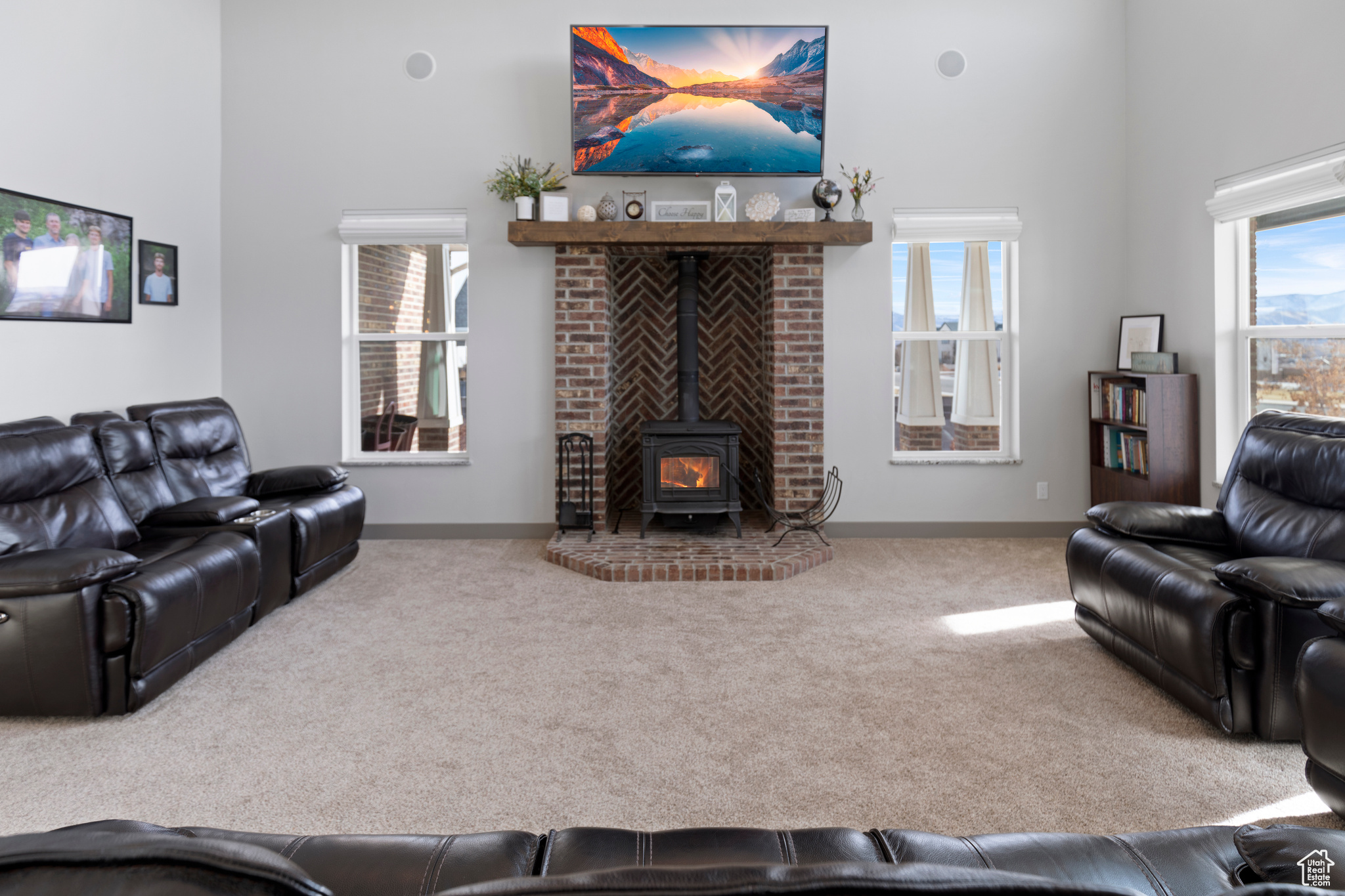 Carpeted living room featuring a wealth of natural light and a wood stove