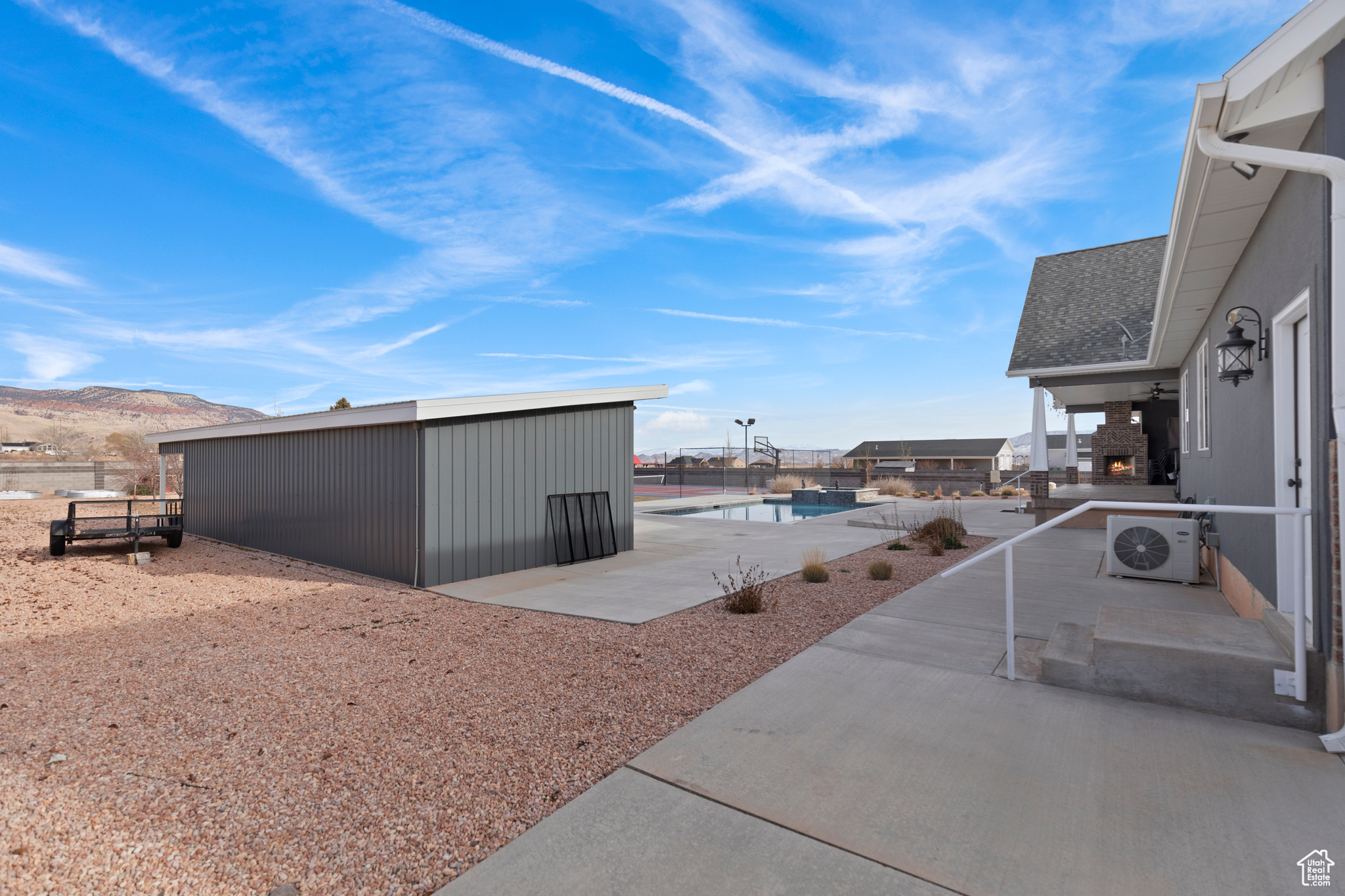 Exterior space with a storage unit, a patio, a mountain view, and a fenced in pool