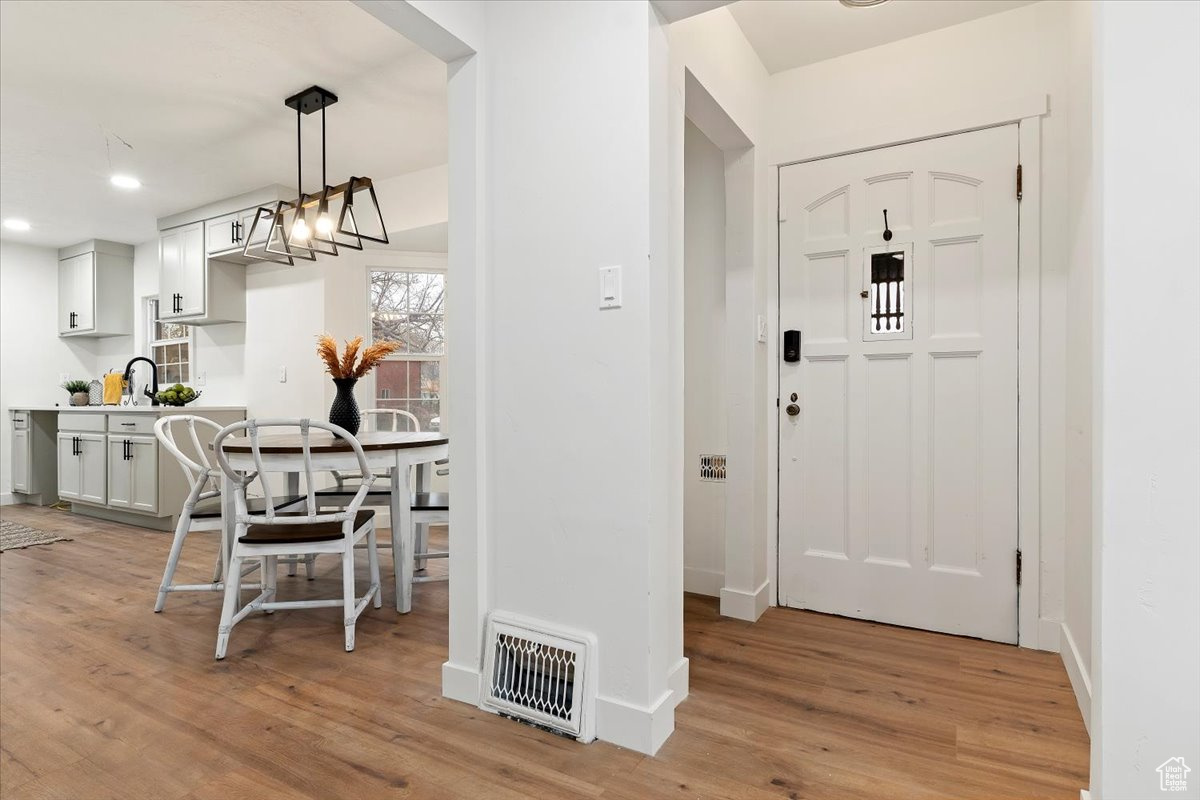 Entrance foyer featuring a chandelier, sink, and light wood-type flooring