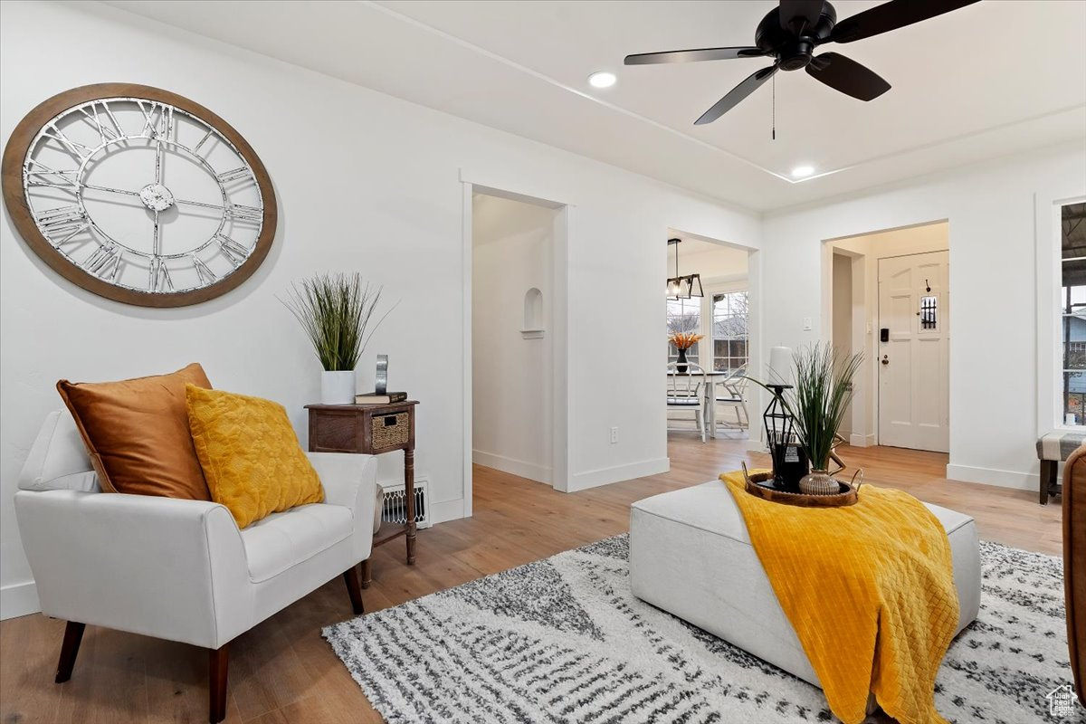 Interior space with light hardwood / wood-style flooring and ceiling fan with notable chandelier