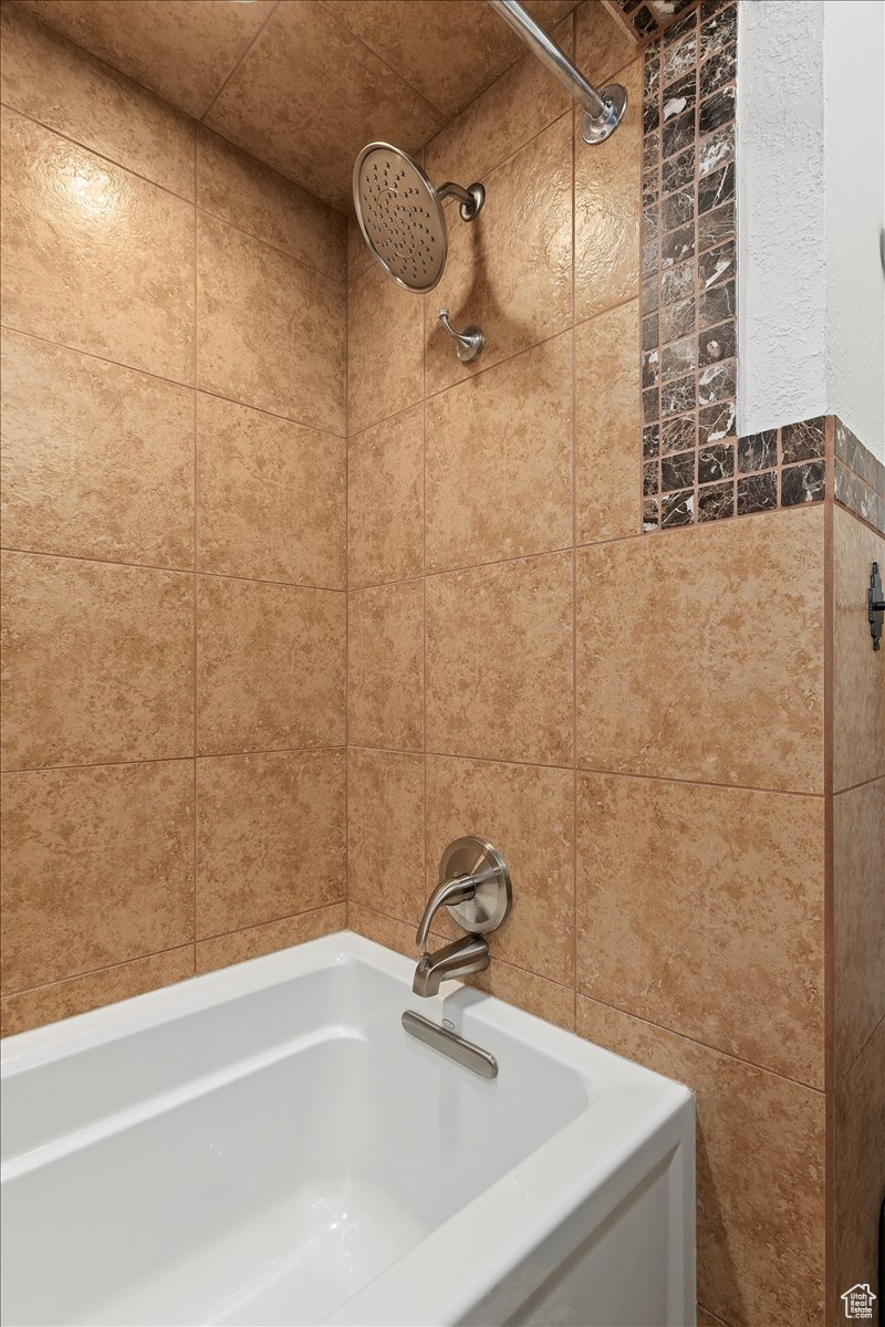 Bathroom featuring tile walls and tiled shower / bath combo