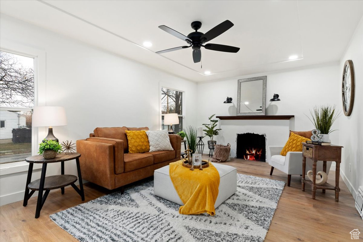 Living room with light hardwood / wood-style floors and ceiling fan