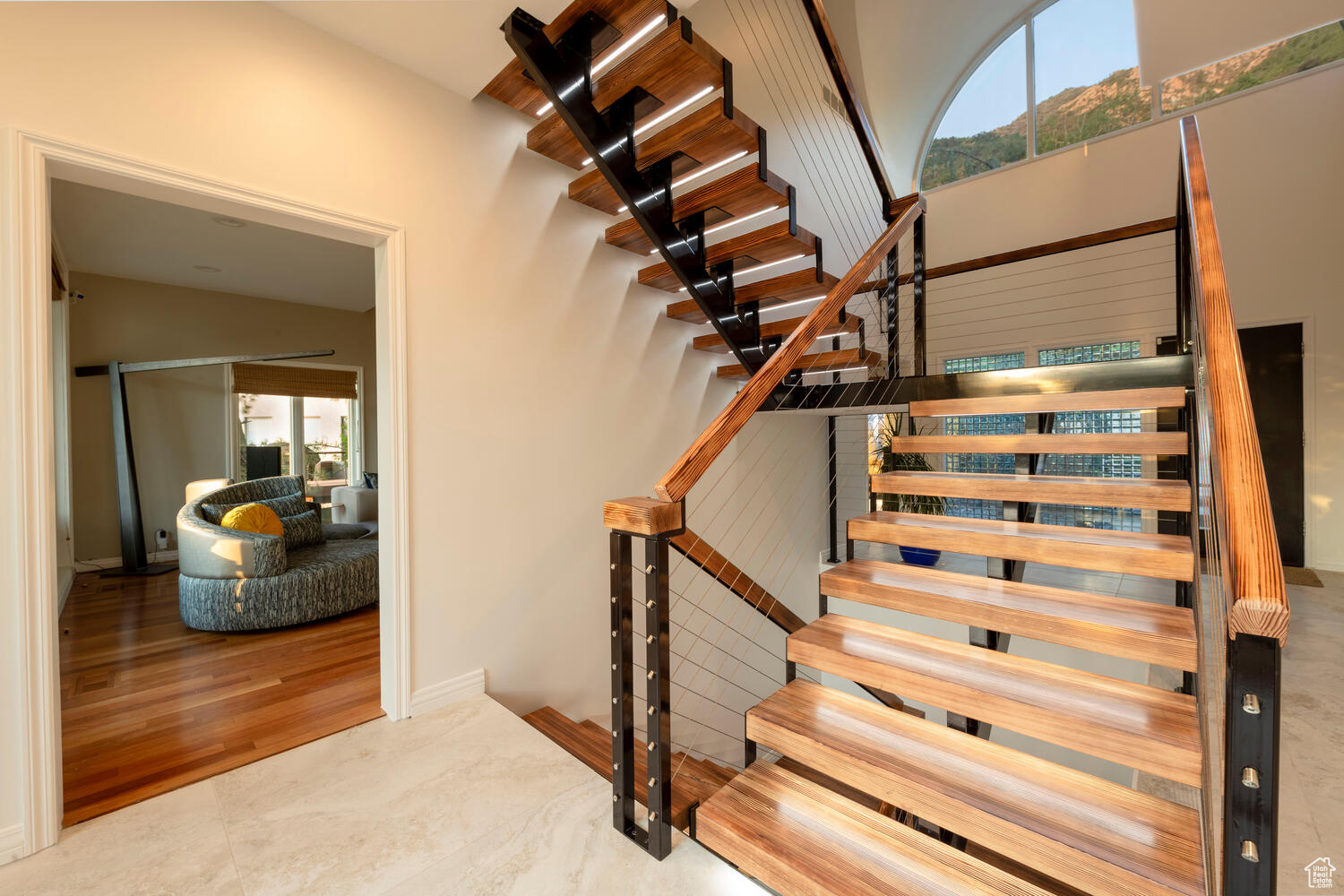 Stairway to the downstairs level featuring wood flooring
