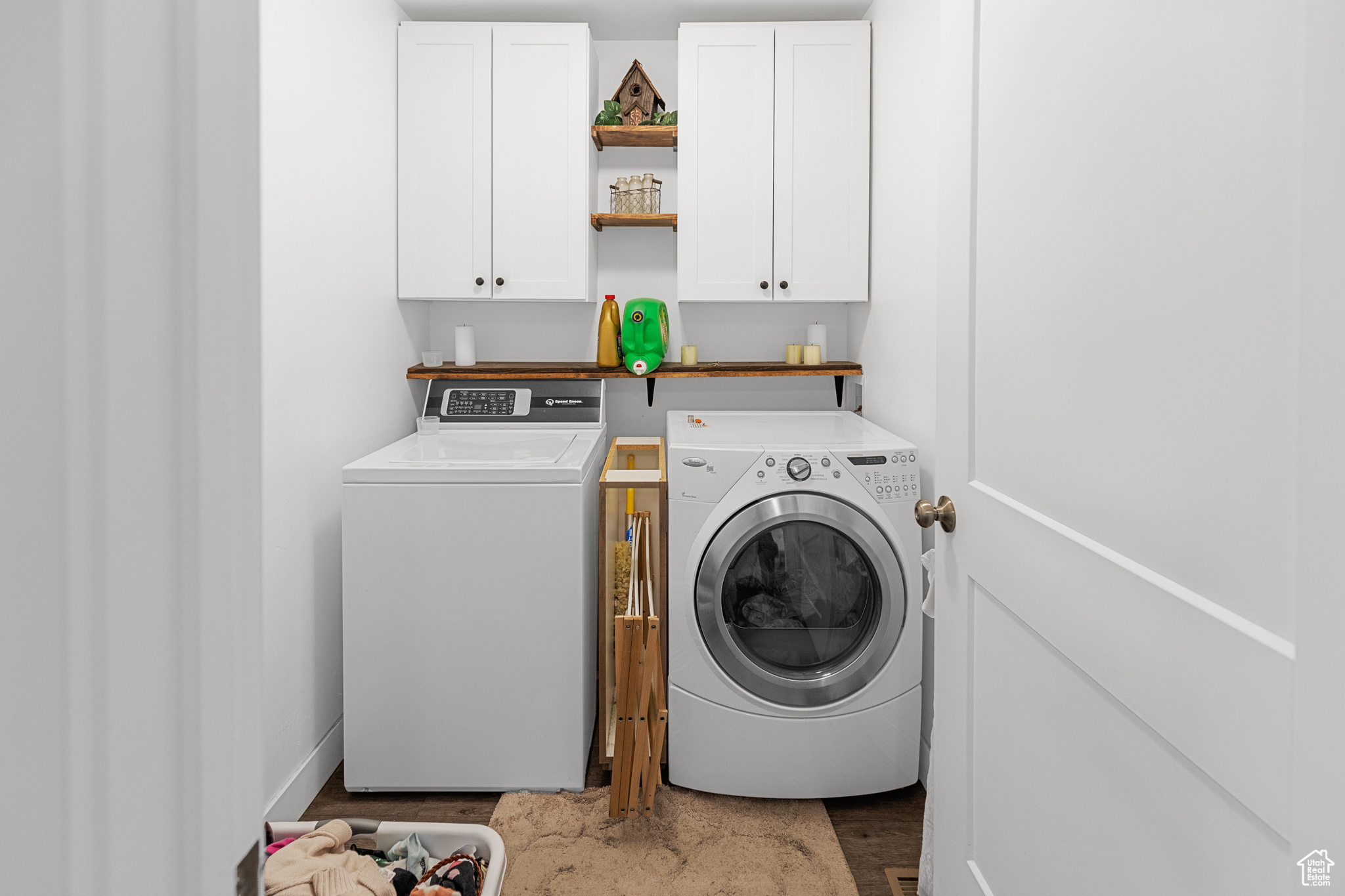 Laundry room featuring dark hardwood / wood-style floors, cabinets, and washer and clothes dryer