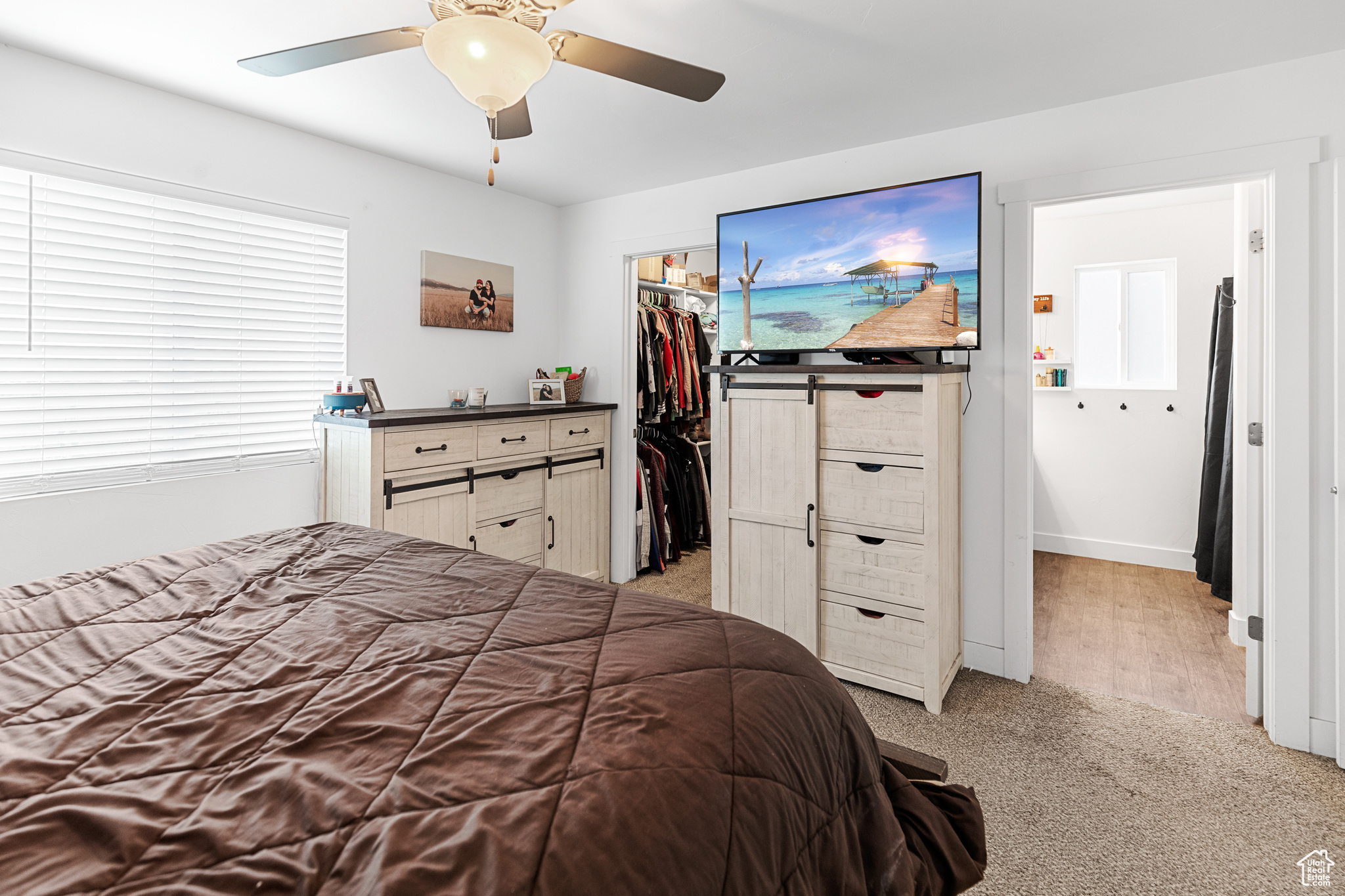 Bedroom featuring light hardwood / wood-style flooring, a closet, a spacious closet, and ceiling fan