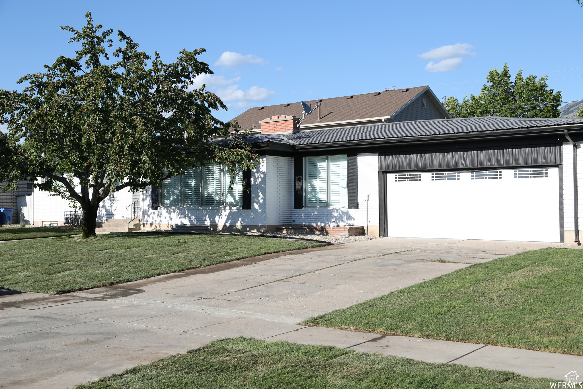 View of front of property with a garage and a front lawn