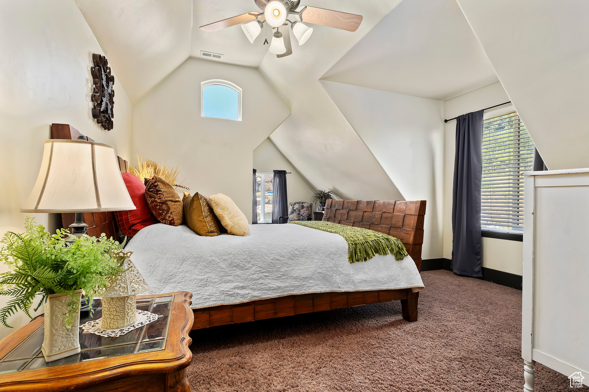 Bedroom with lofted ceiling, dark colored carpet, and ceiling fan