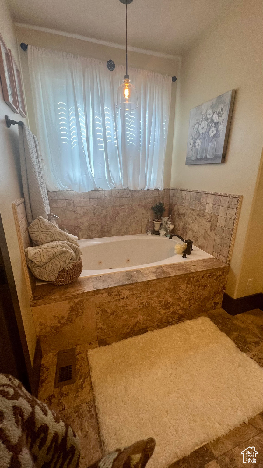 Bathroom featuring tile floors and tiled tub