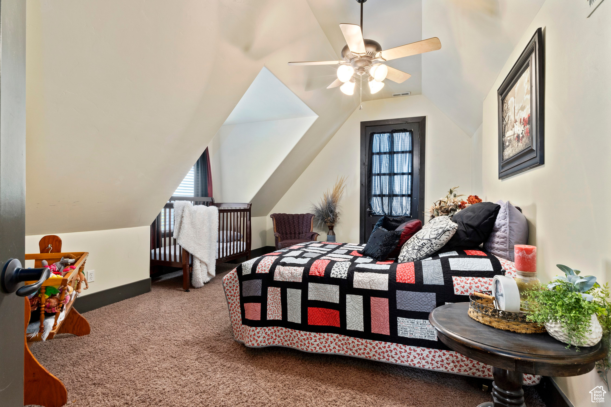 Carpeted bedroom with multiple windows, vaulted ceiling, and ceiling fan