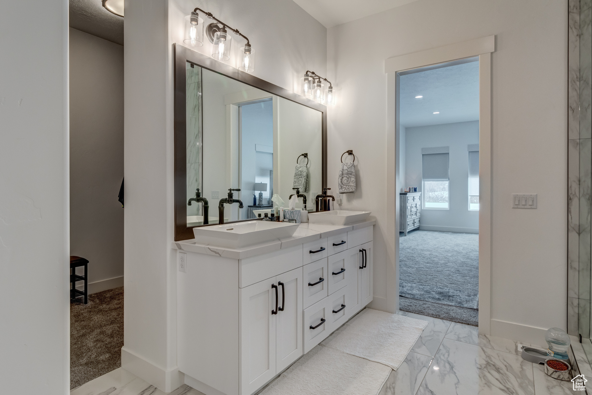 Bathroom featuring tile floors, large vanity, and double sink