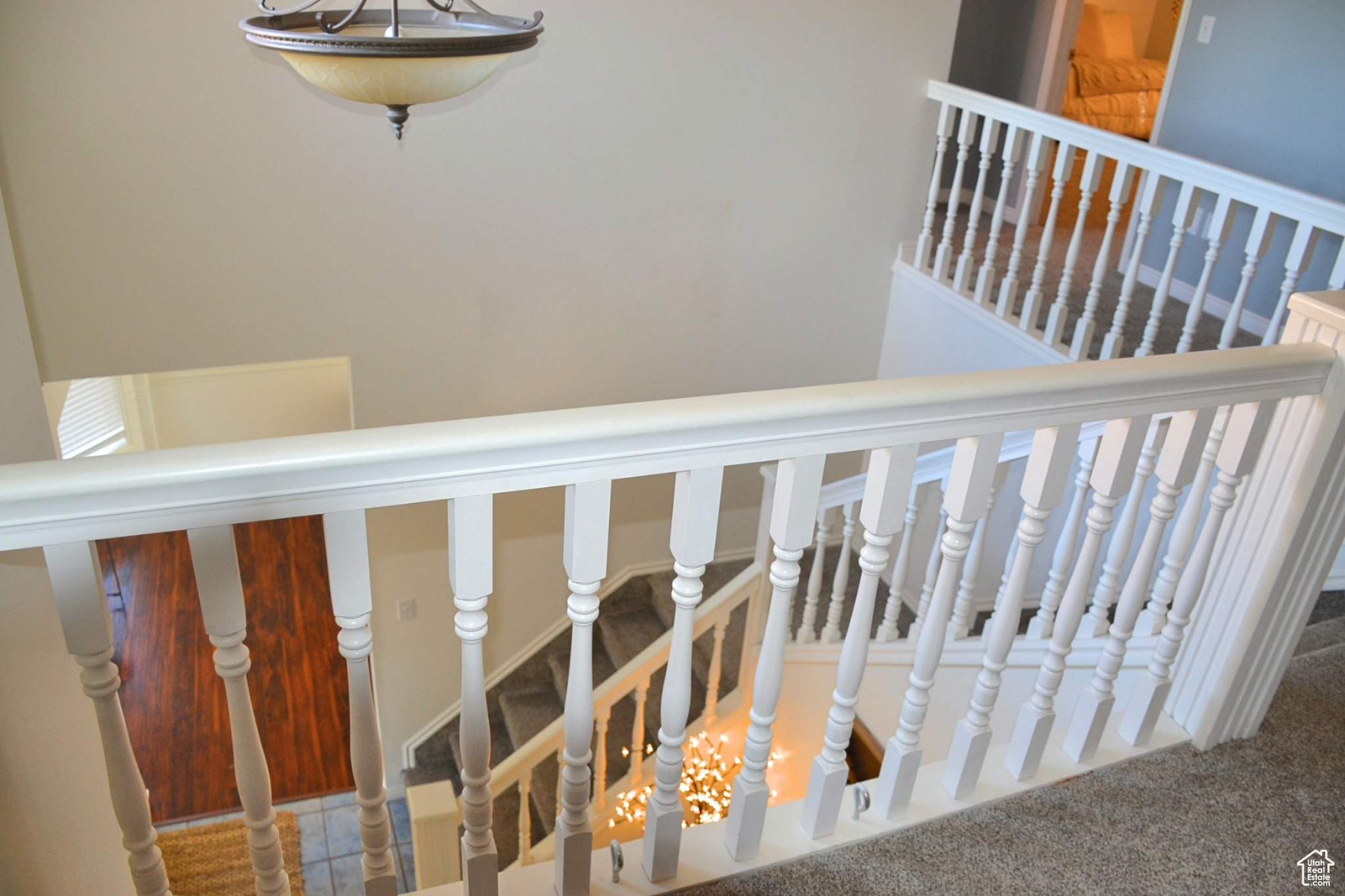 Staircase with a chandelier and carpet