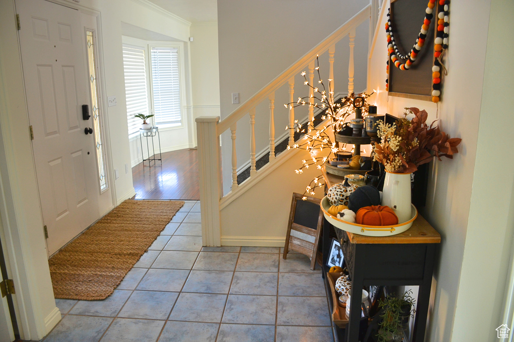 Tiled entryway featuring ornamental molding