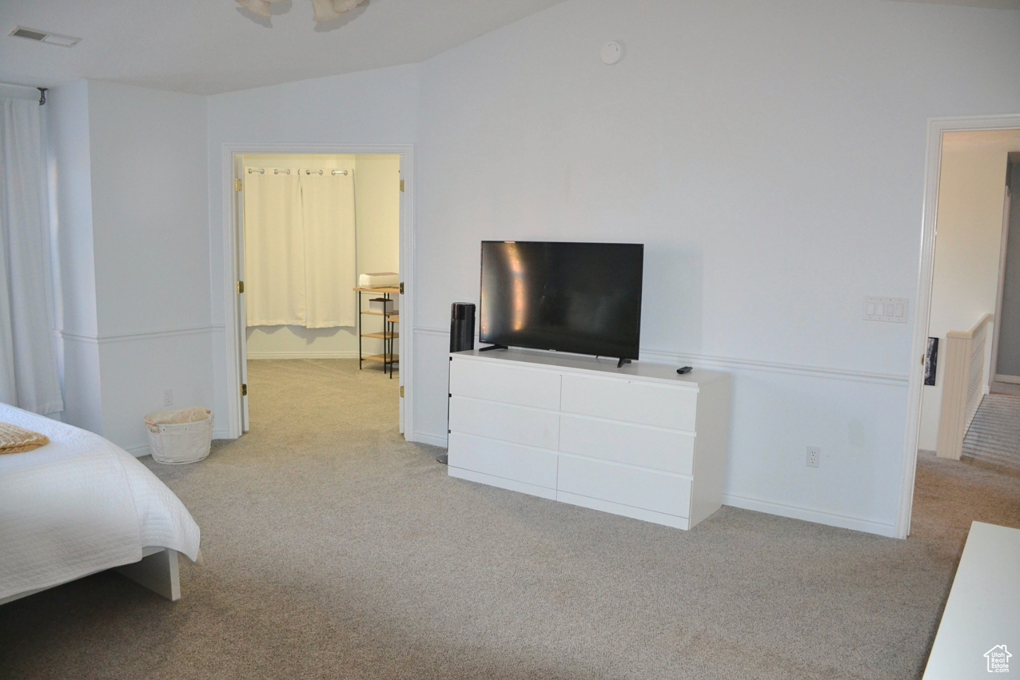 Bedroom featuring light colored carpet and lofted ceiling