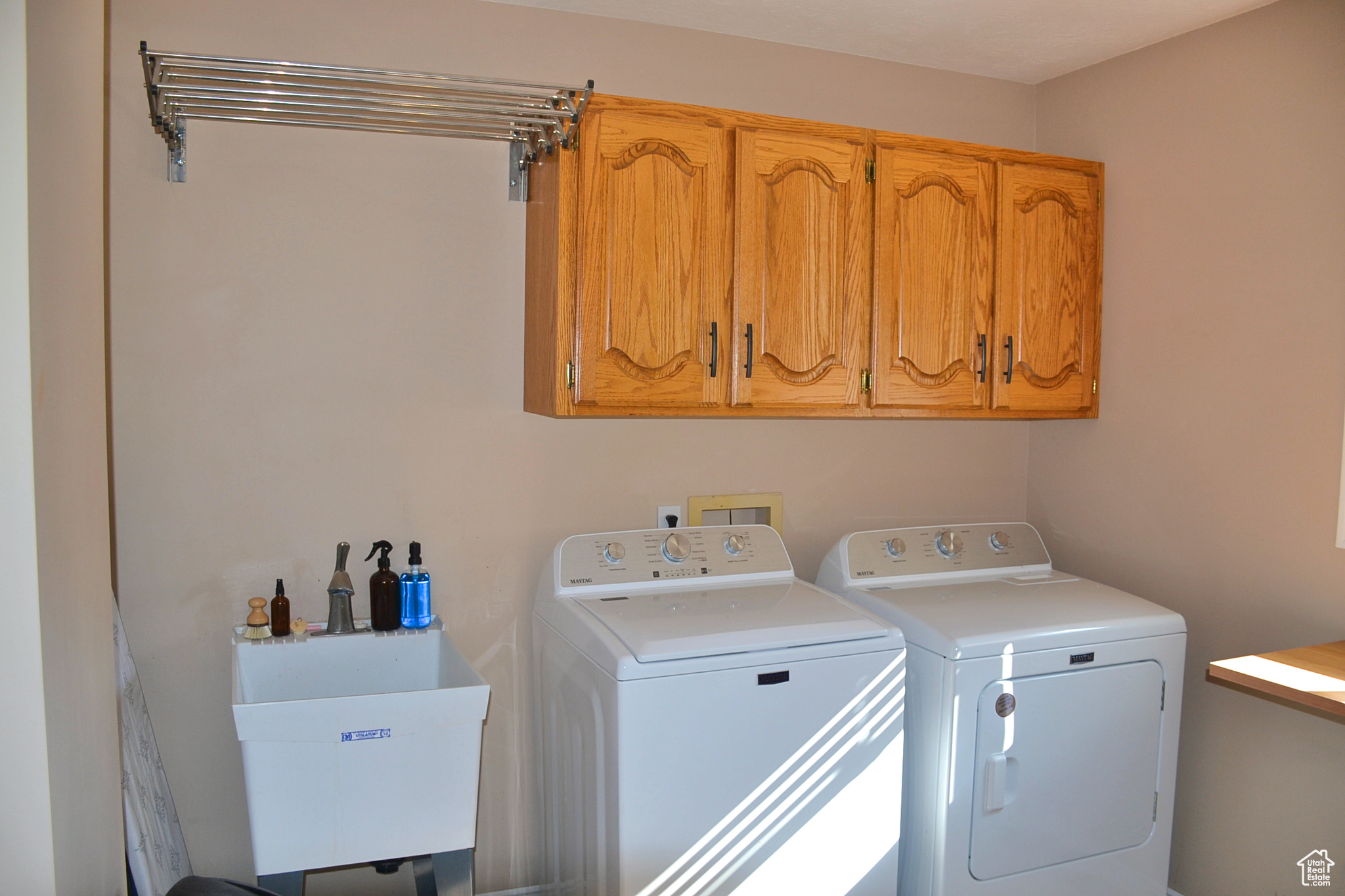 Laundry area featuring sink, cabinets, and washing machine and dryer