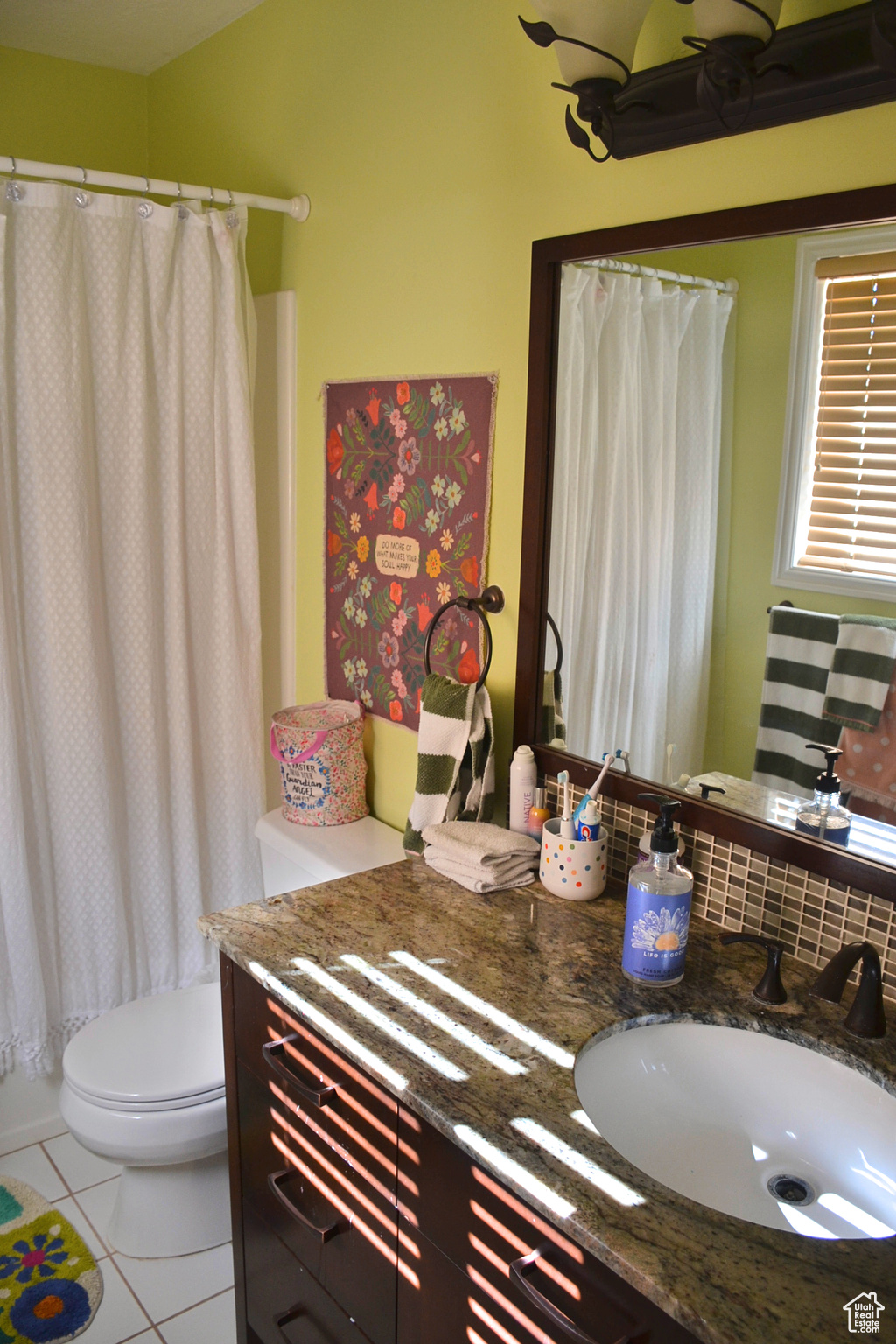 Bathroom with tile floors, toilet, and large vanity