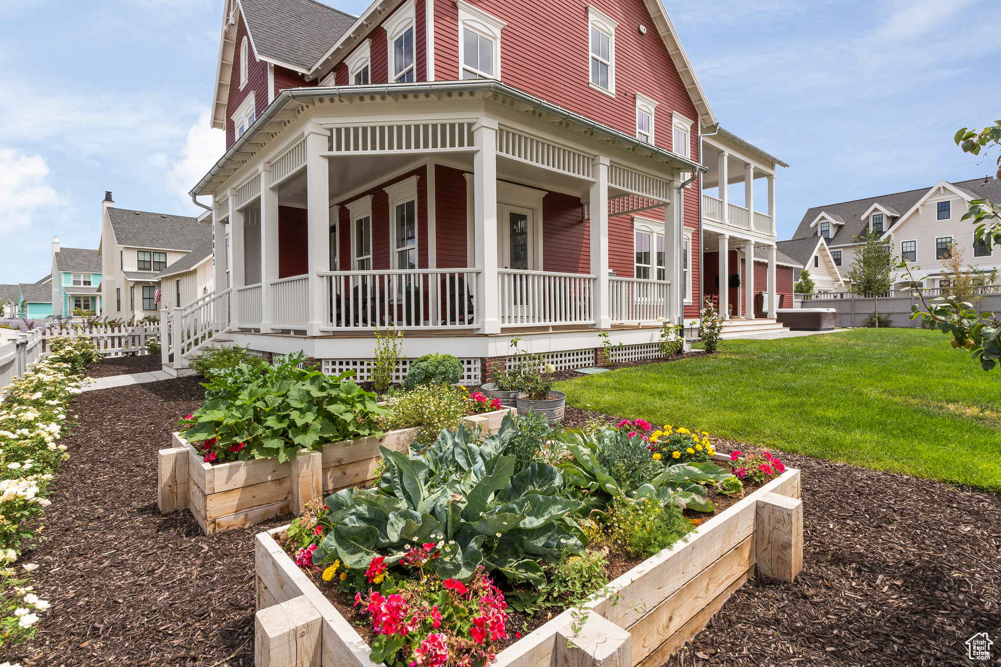 View of property exterior with a lawn and raised vegetable beds