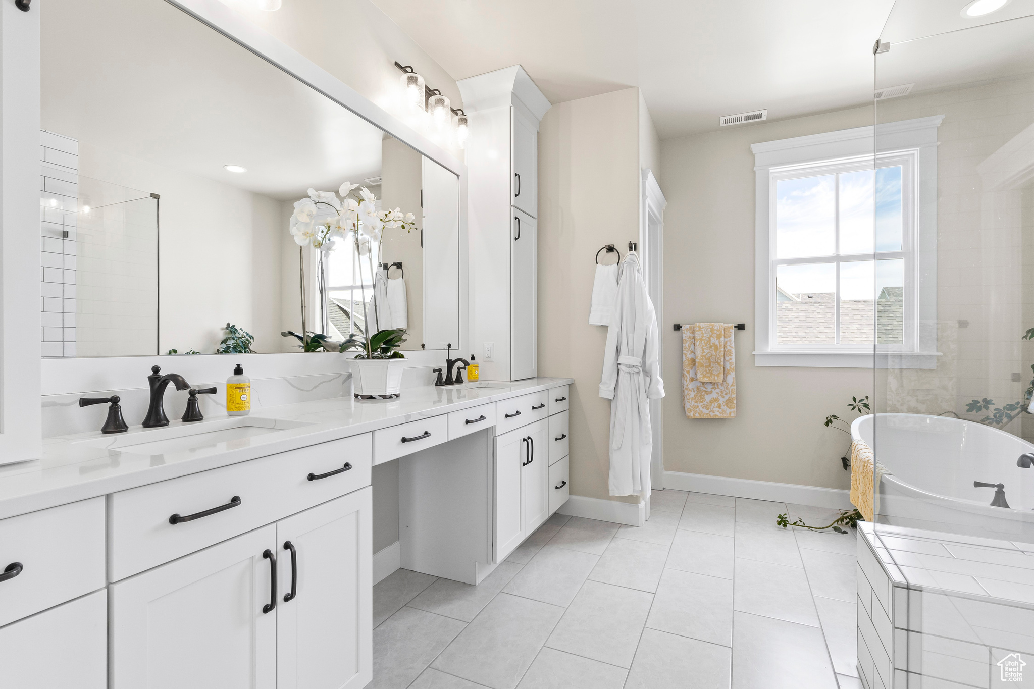 Master Bathroom with tile floors, separate shower and freestanding tub, and dual bowl vanity