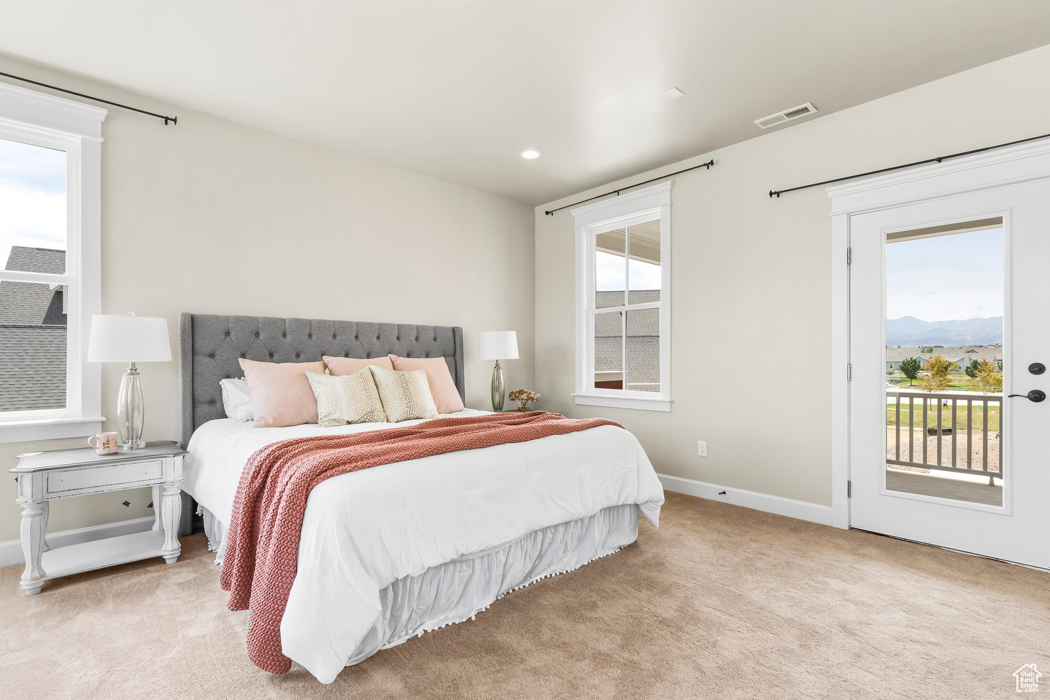 Master Bedroom with light carpet and access to exterior deck