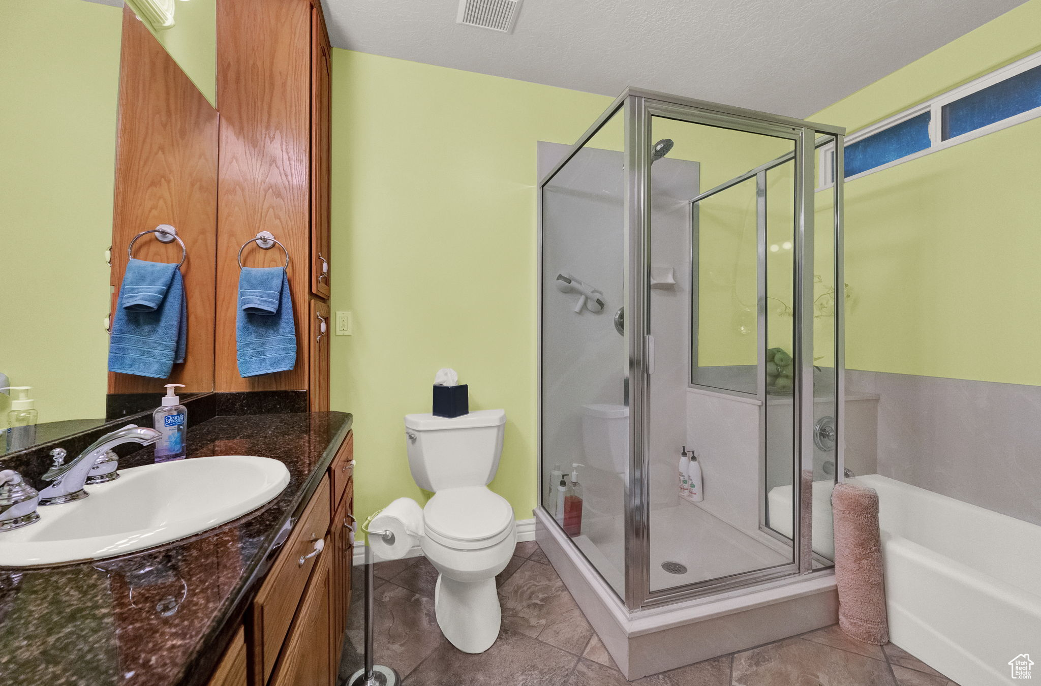 Full bathroom featuring vanity, a textured ceiling, toilet, independent shower and bath, and tile flooring