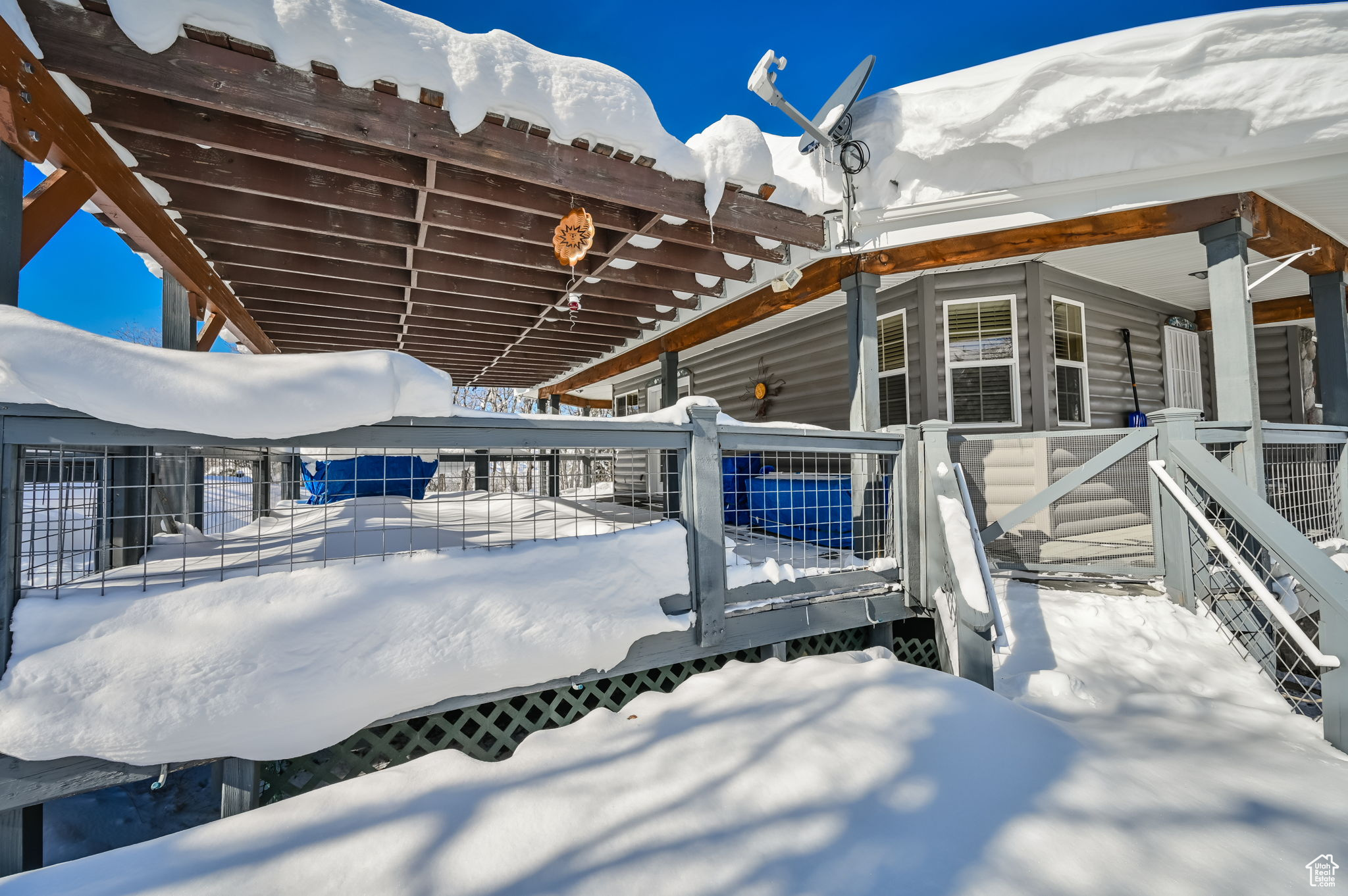 Snow covered patio featuring a pergola