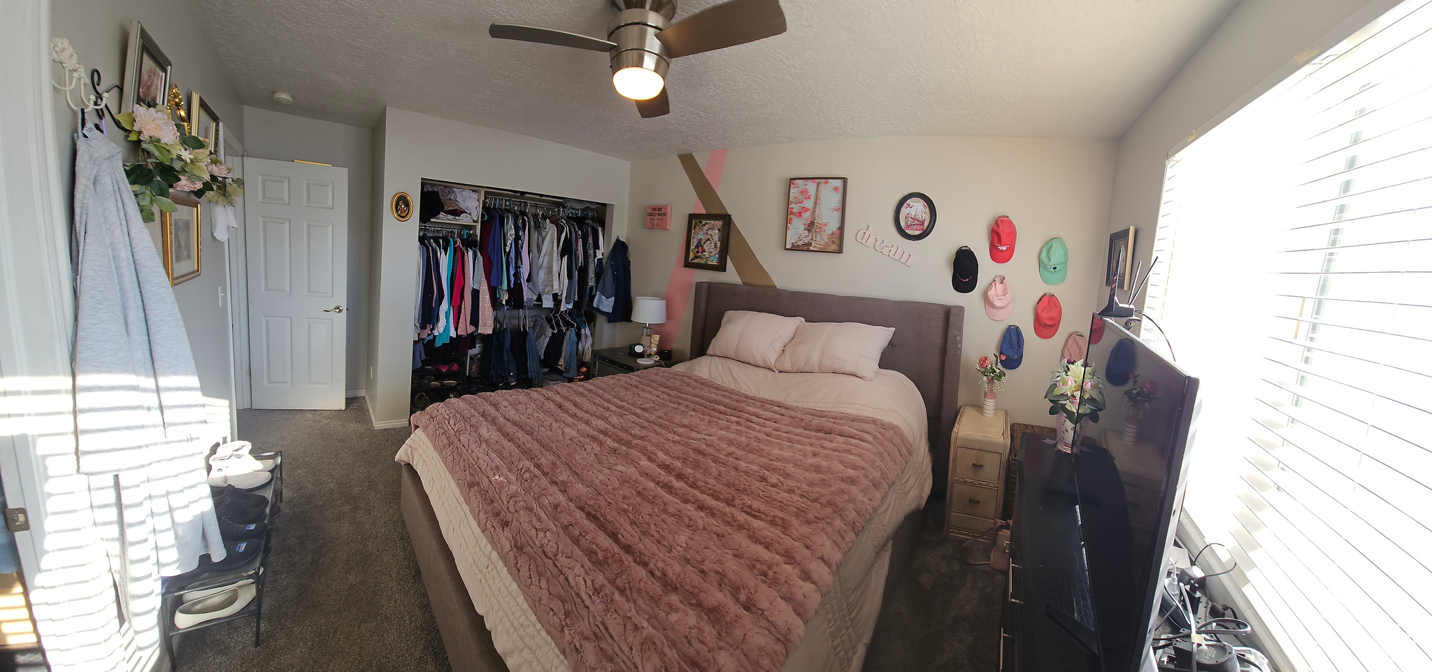 Bedroom with a closet, dark carpet, a textured ceiling, and ceiling fan