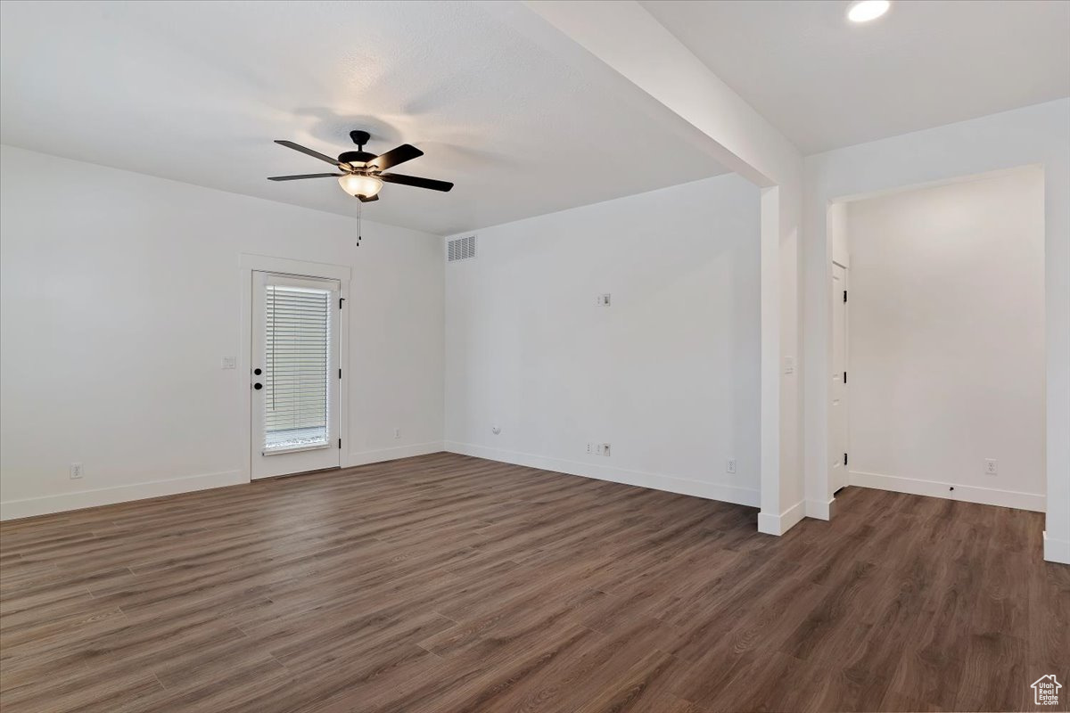 Unfurnished room featuring dark hardwood / wood-style flooring and ceiling fan