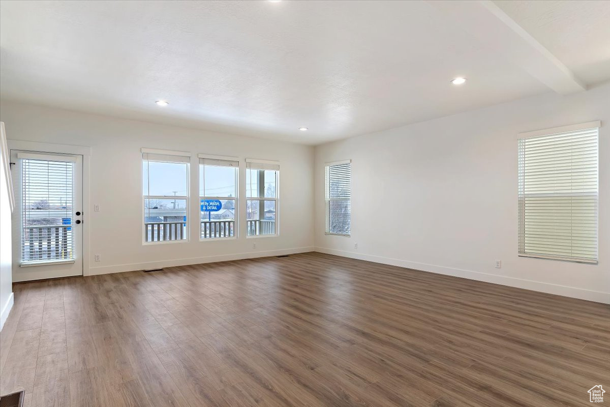 Unfurnished room with dark hardwood / wood-style flooring and a wealth of natural light