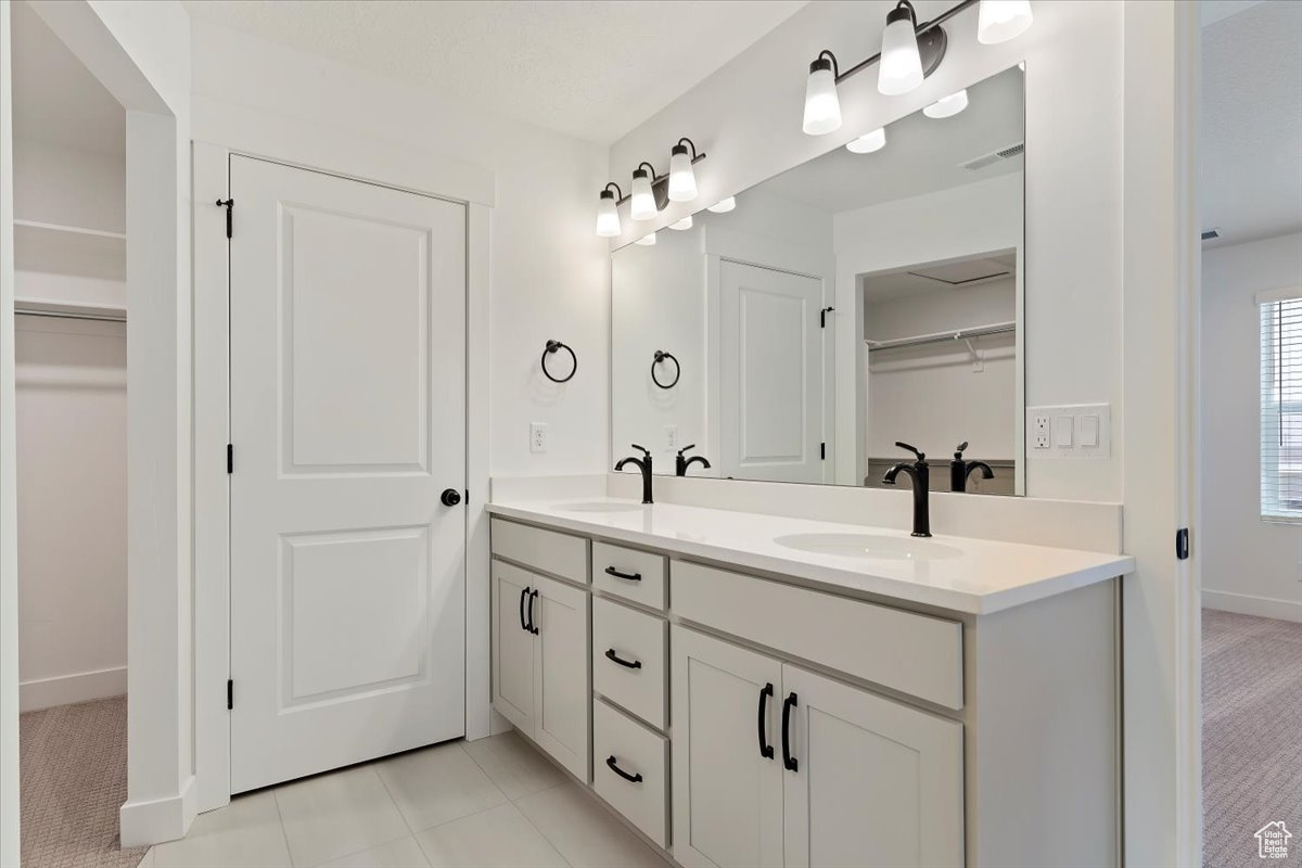 Bathroom featuring dual vanity and tile flooring