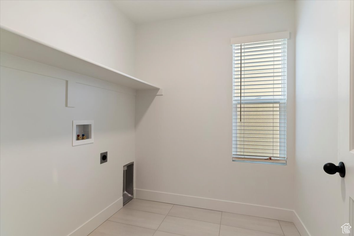 Clothes washing area featuring hookup for a washing machine, light tile flooring, and hookup for an electric dryer