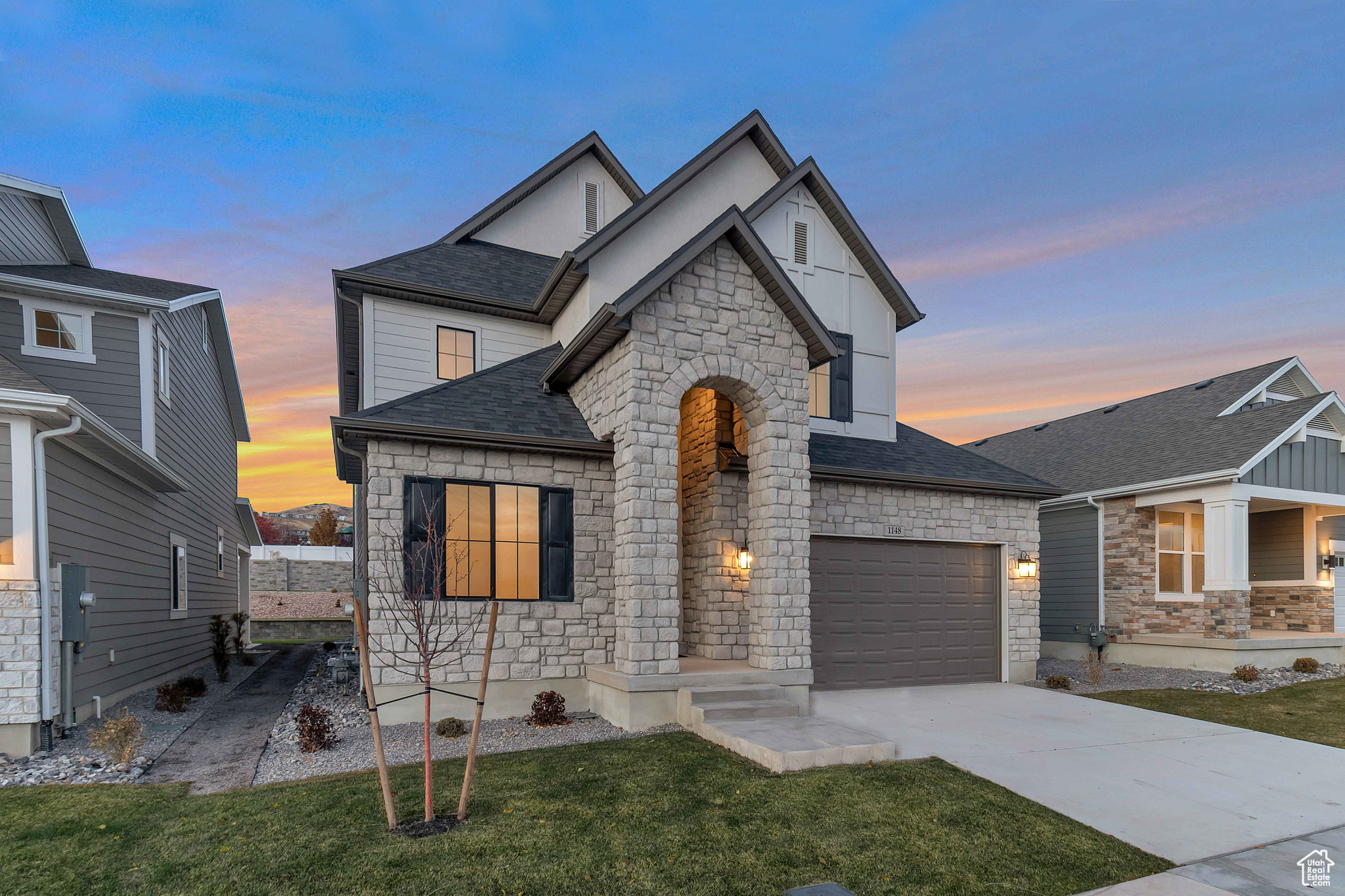 View of front of property with a yard and a garage