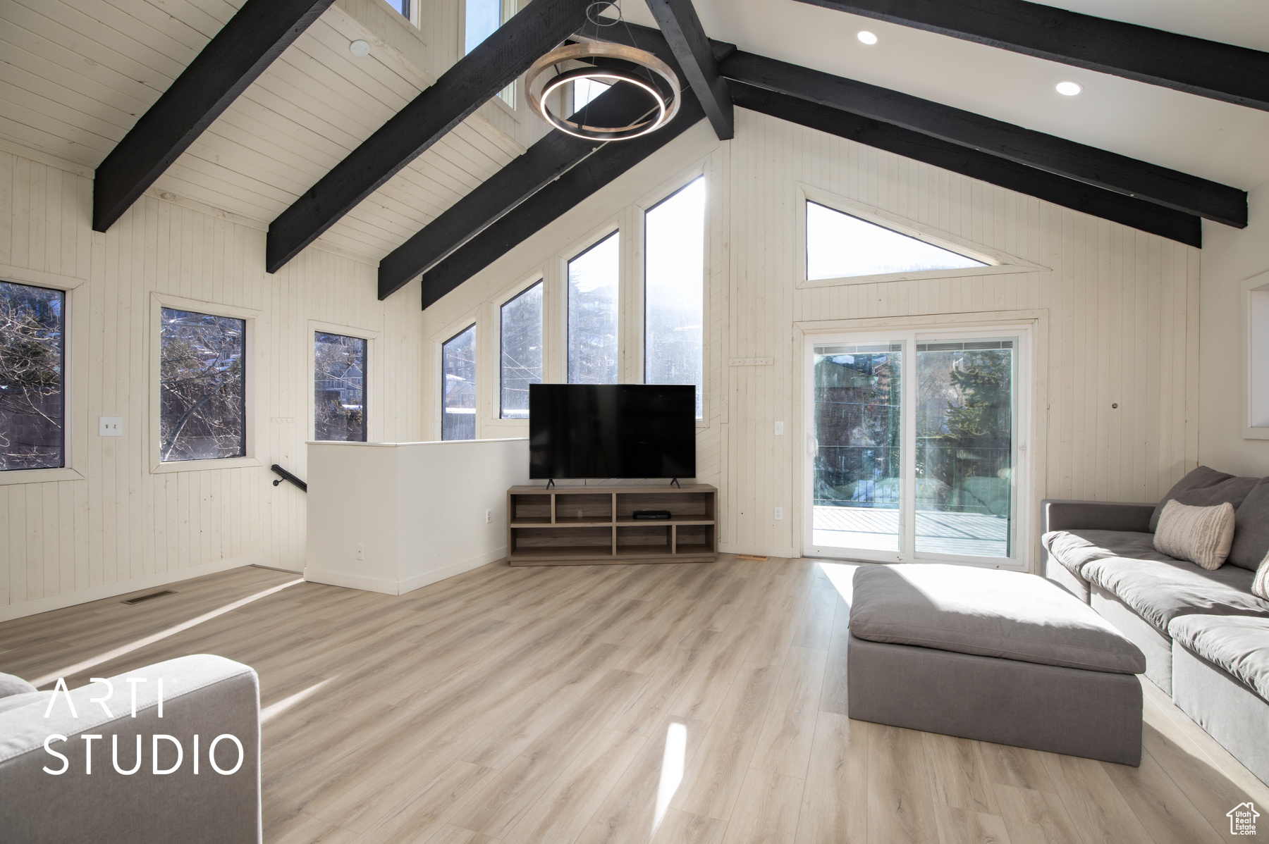 Living room featuring  wood-style floors, beamed ceiling, a notable chandelier, clerestory windows and lots of sunlight