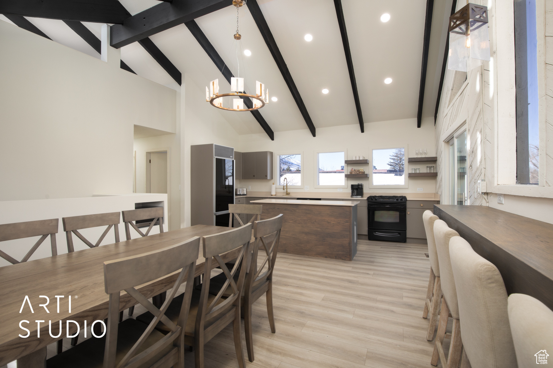 Kitchen & Dining with gray cabinets, wood-style floors, beamed ceiling, a notable chandelier, clerestory windows and lots of sunlight
