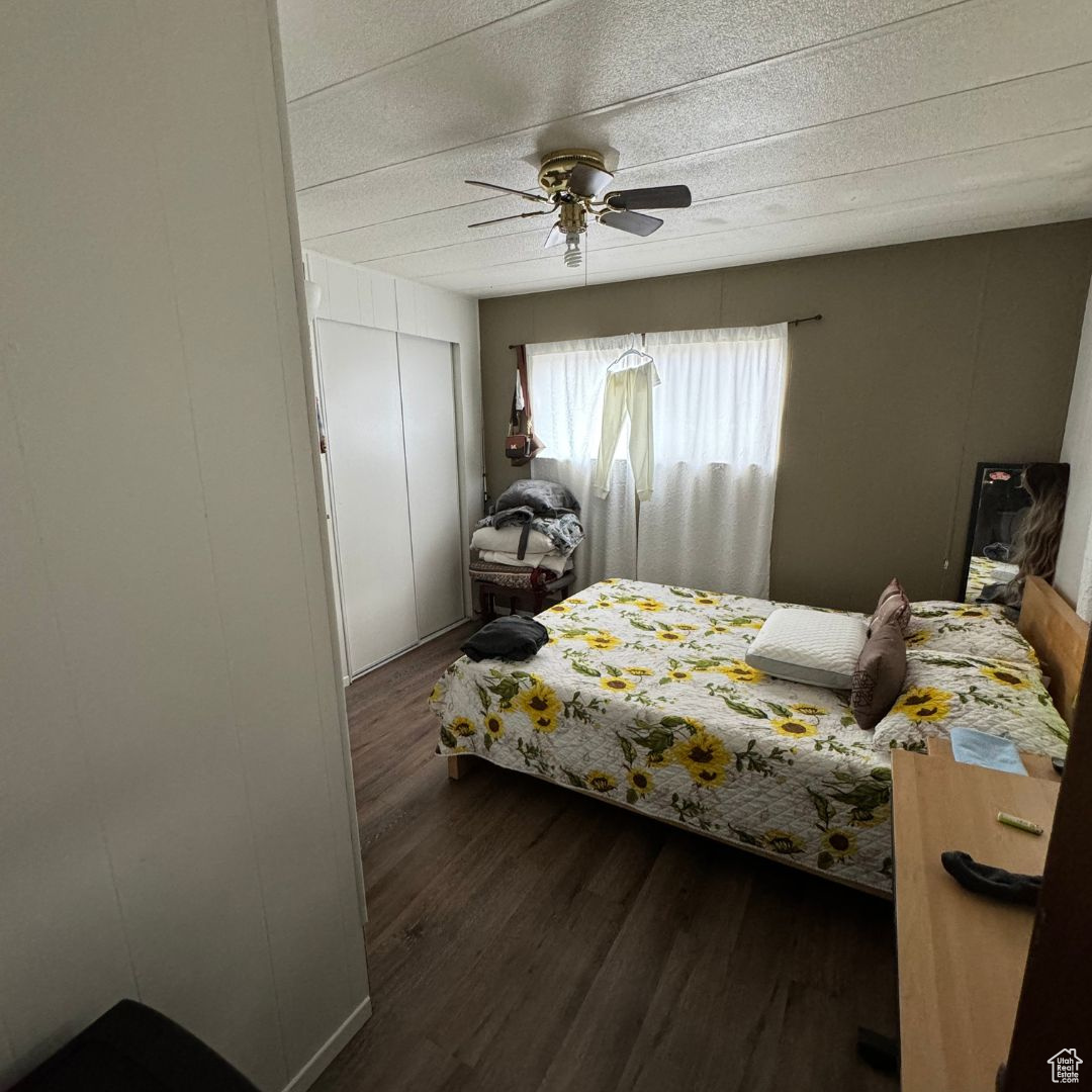 Bedroom featuring a closet, dark hardwood / wood-style floors, and ceiling fan