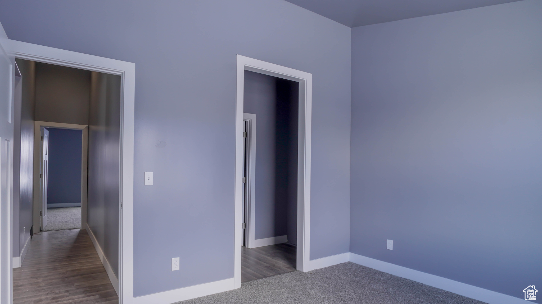 Unfurnished bedroom with dark colored carpet