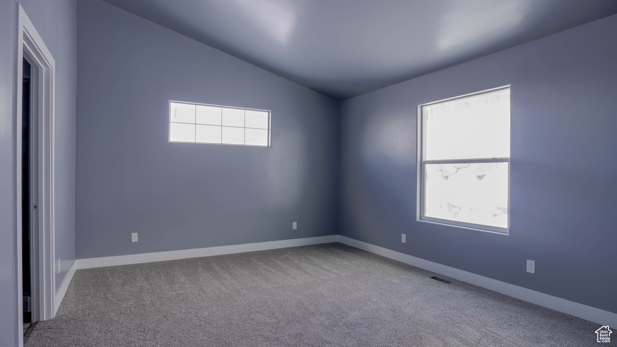 Carpeted empty room featuring lofted ceiling and a healthy amount of sunlight
