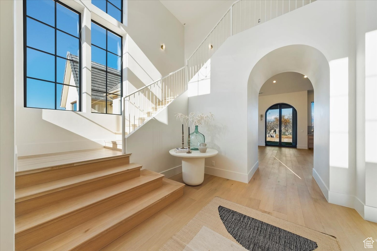 Stairway featuring light hardwood / wood-style floors and a high ceiling