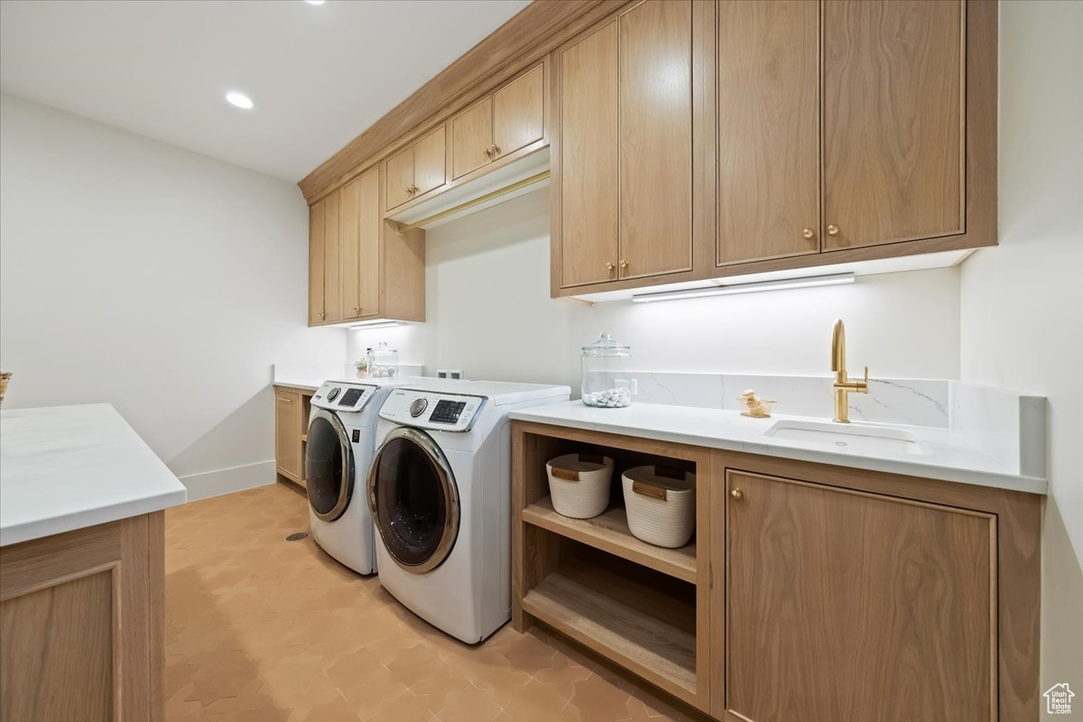 Laundry area featuring sink, cabinets, washing machine and dryer, and light tile floors