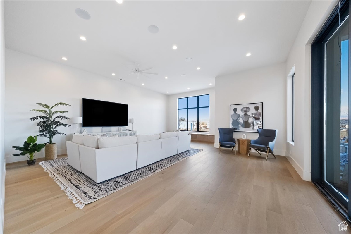 Living room with light hardwood / wood-style flooring and ceiling fan