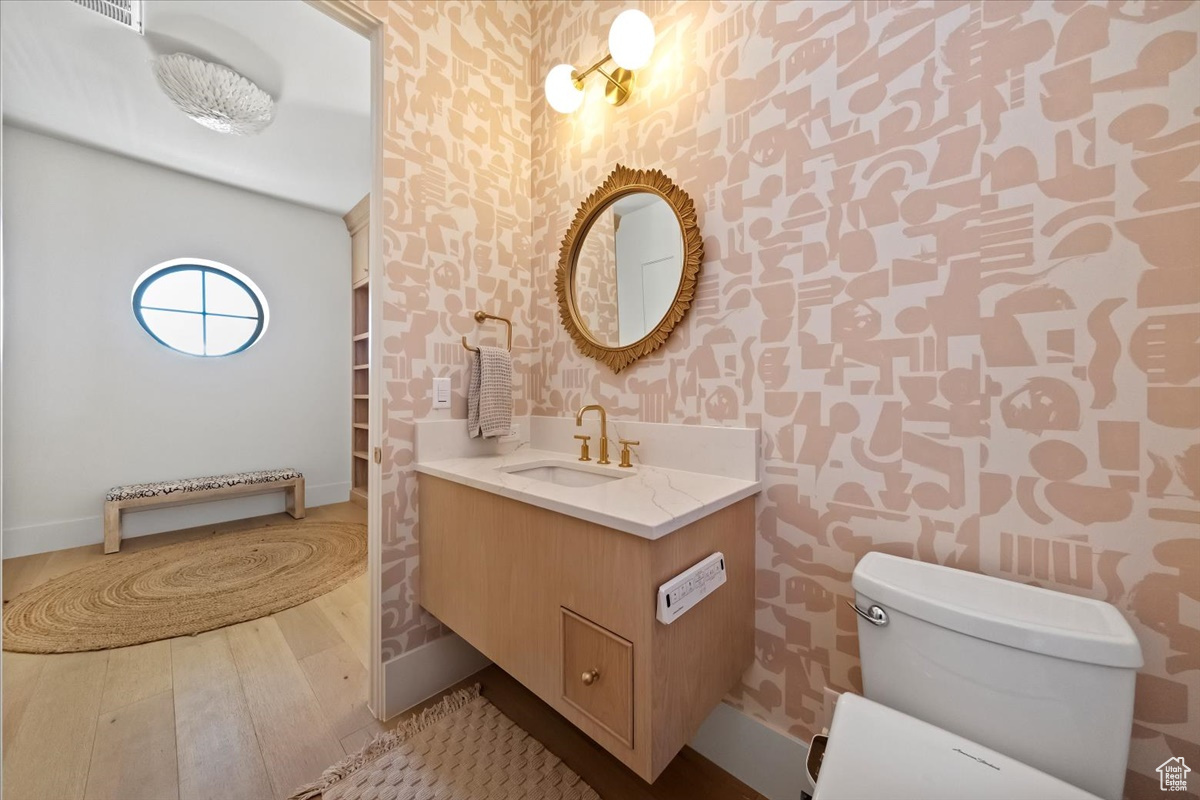 Bathroom with vanity, toilet, and hardwood / wood-style flooring