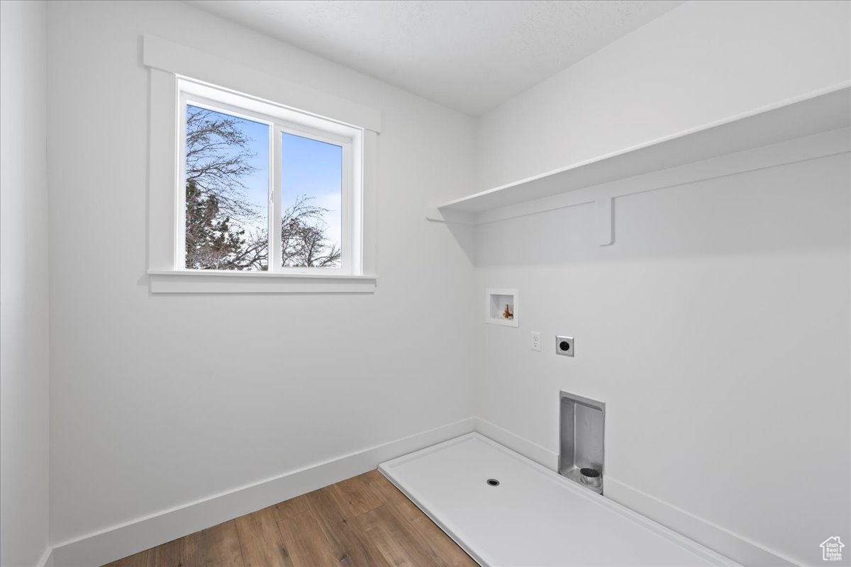 Clothes washing area with washer hookup, dark wood-type flooring, and electric dryer hookup