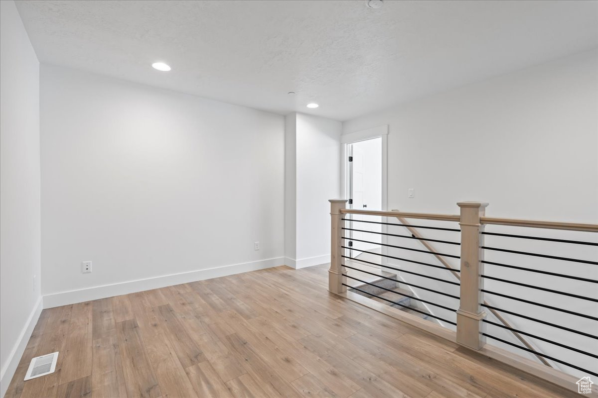 Empty room with light hardwood / wood-style flooring