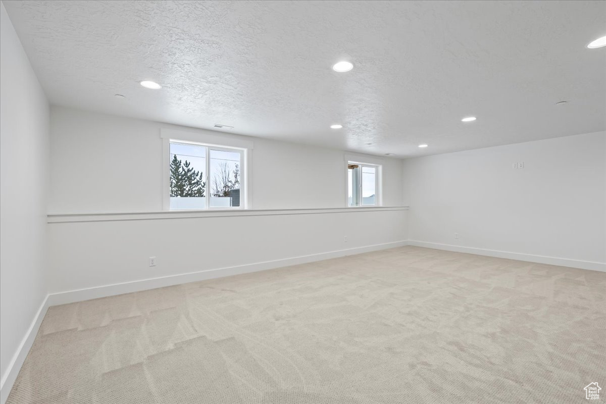 Spare room with a textured ceiling and light colored carpet