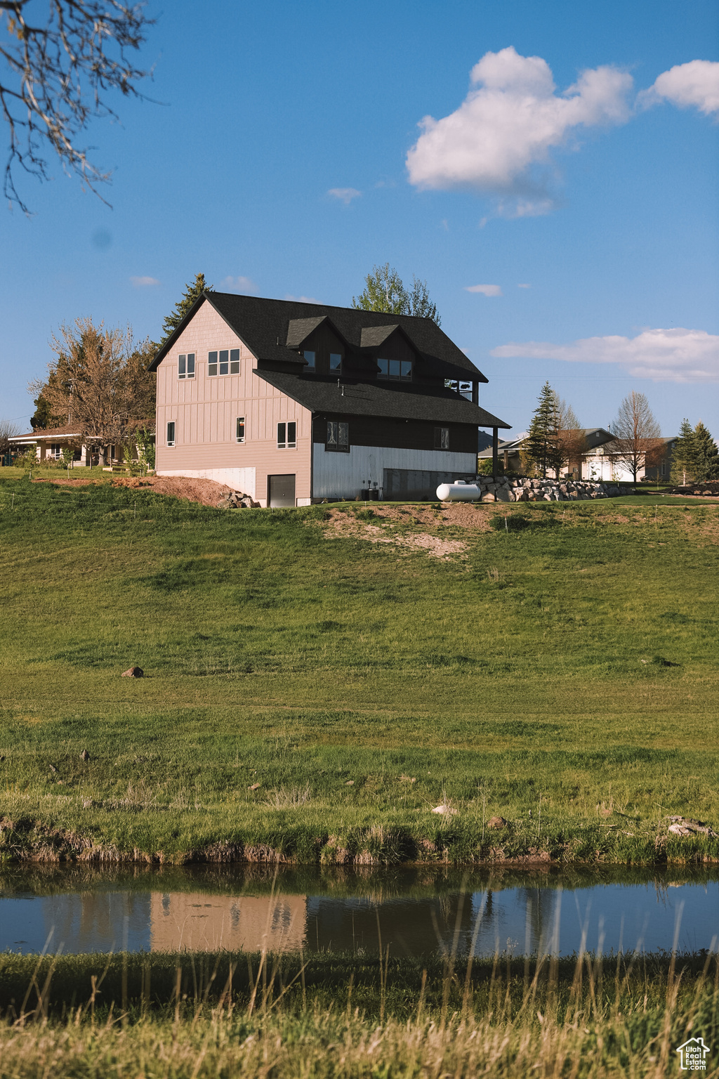 View of front facade featuring a water view and a front lawn