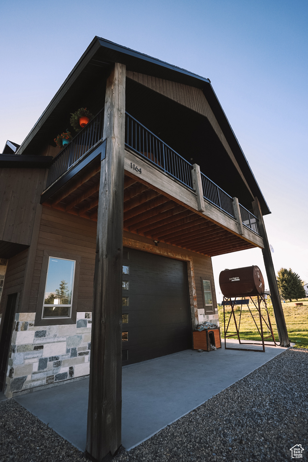 View of property exterior featuring a garage and a balcony