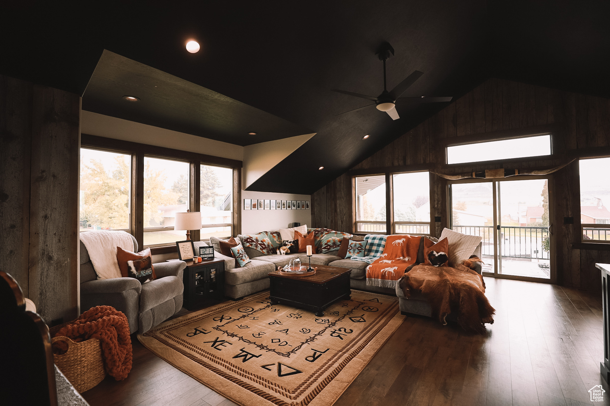 Living room with a healthy amount of sunlight, ceiling fan, and hardwood / wood-style flooring