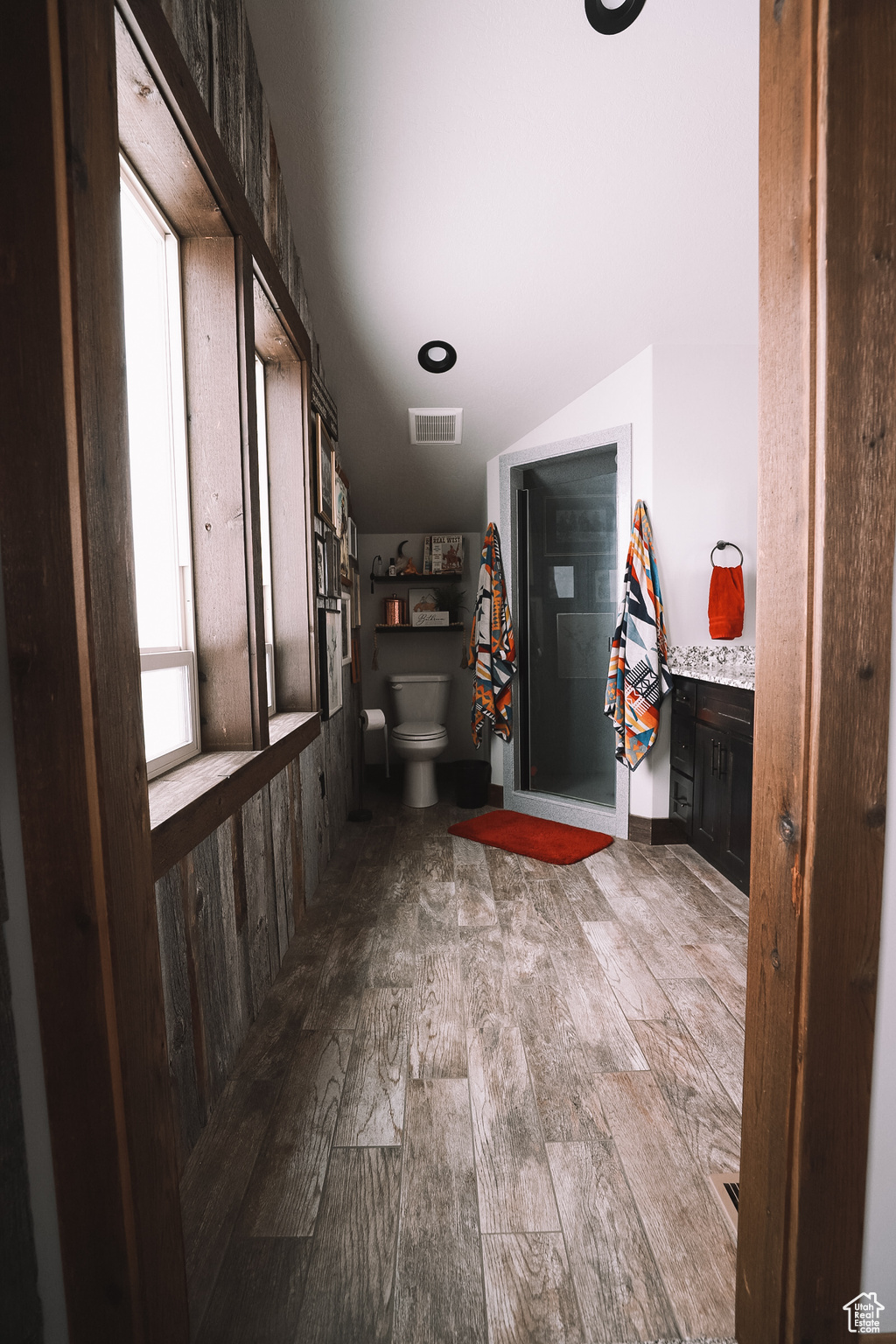 Primary bathroom with dark hardwood / wood-style floors and a healthy amount of sunlight