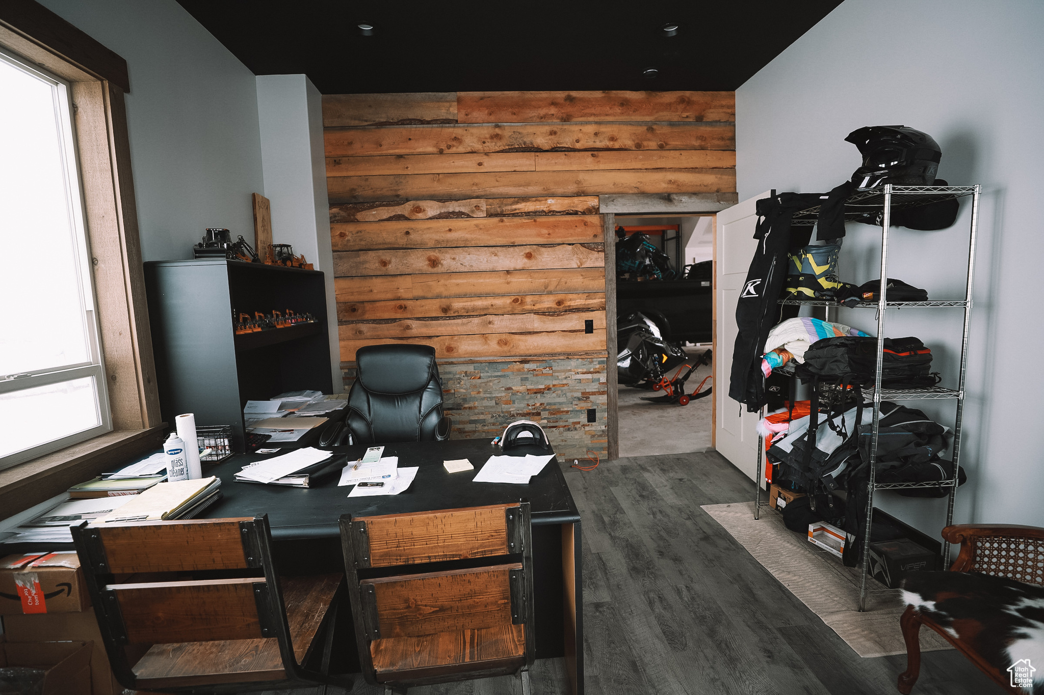 Home office on the lower level, connected to the garage, featuring dark hardwood / wood-style floors